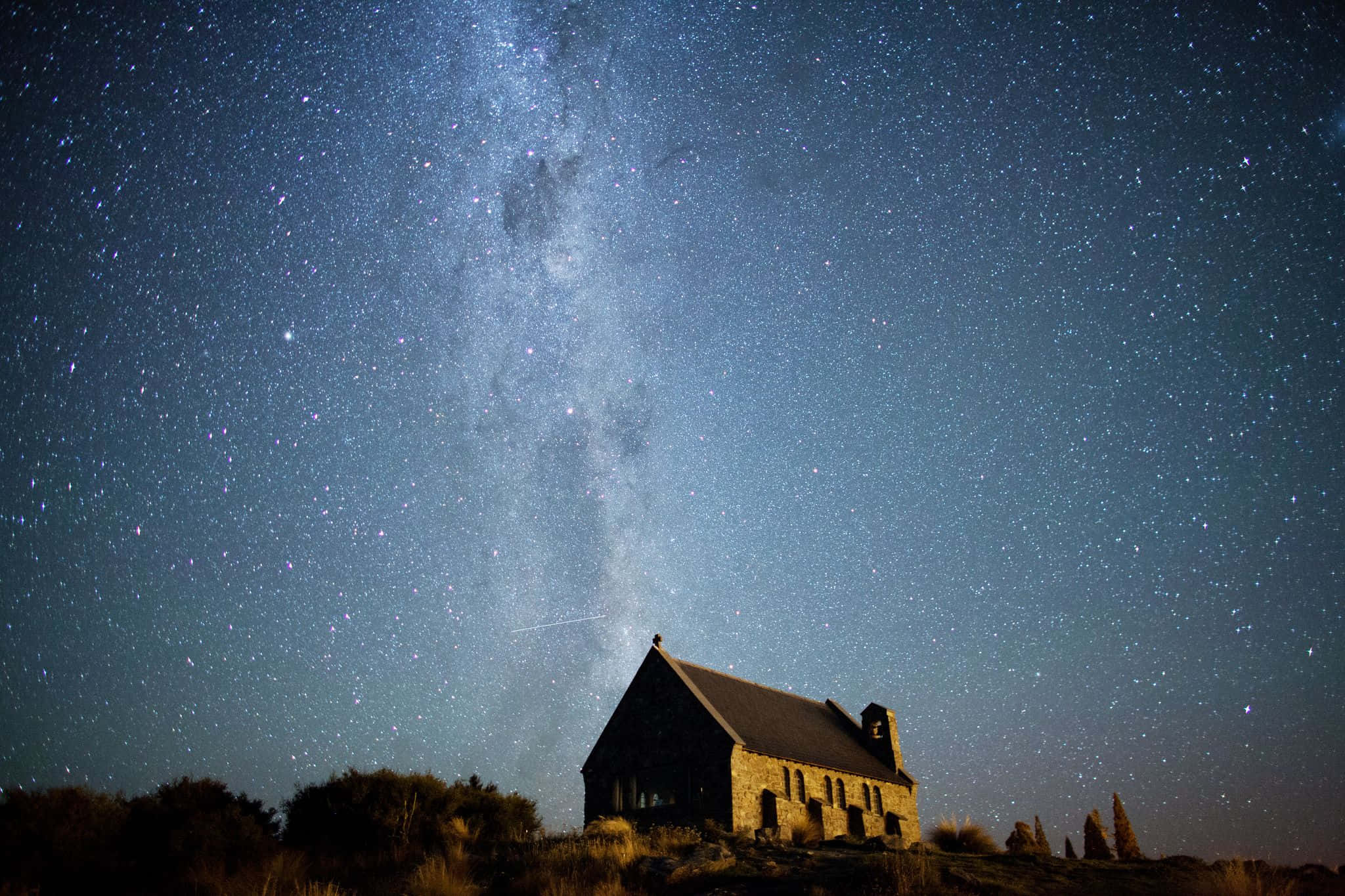教堂下銀河的夜空 壁紙 — 一座孤獨的石頭教堂矗立在令人嘆為觀止的星空下，銀河在頭頂閃耀。