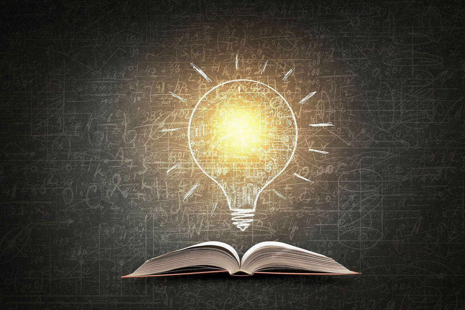 教育燈泡 壁紙 — 一個充滿電路的發光燈泡懸浮在一本打開的書本上方，背景是佈滿方程式的黑板。