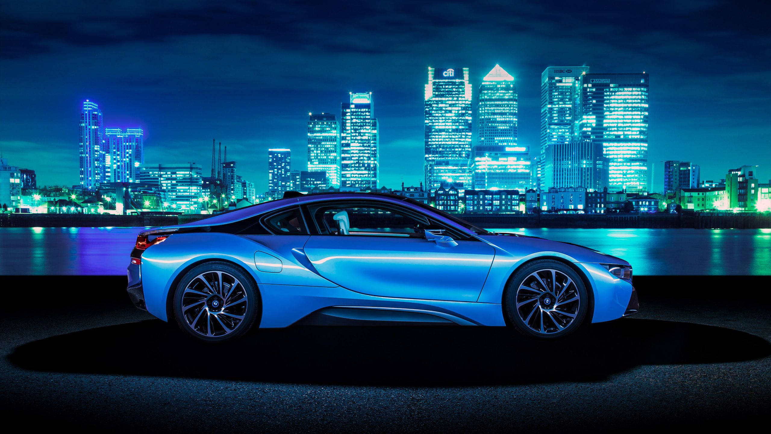 敞開道路上的優雅藍色BMW 壁紙 — 一輛時尚的藍色跑車在霓虹燈下閃耀，背景是未來主義的城市天際線夜景。