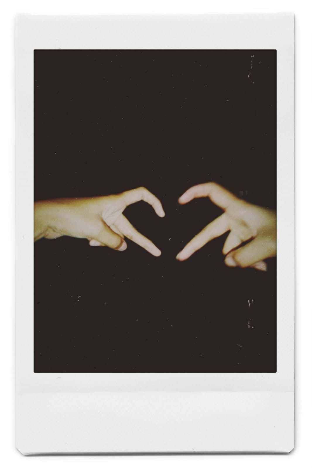 兩隻手在黑暗背景下形成心形，放在Polaroid相框中。 — 寶麗來 GIF 壁紙
