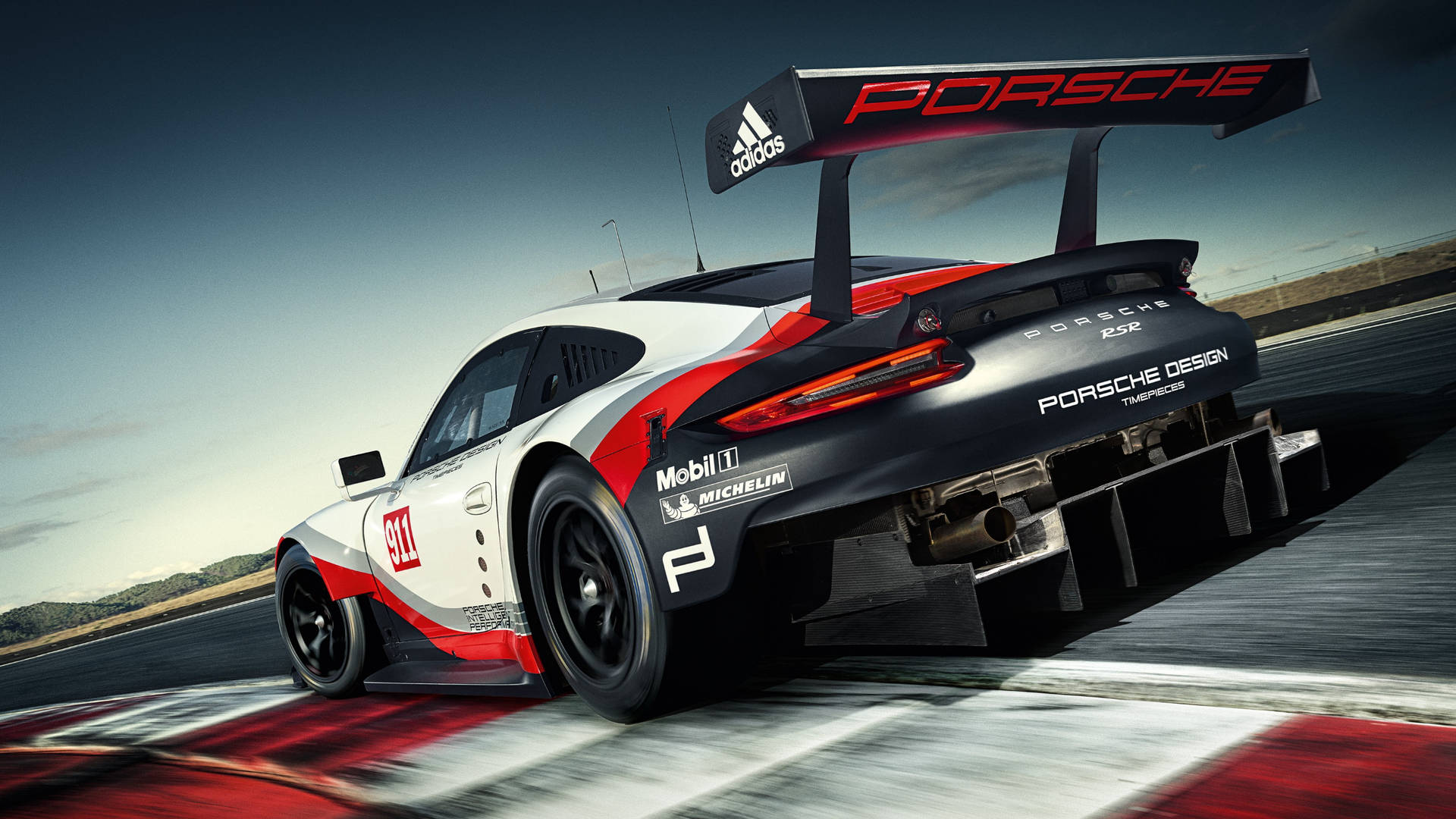 保時捷 911 GT3 R 賽車在賽道上飛馳，帶有動態模糊。