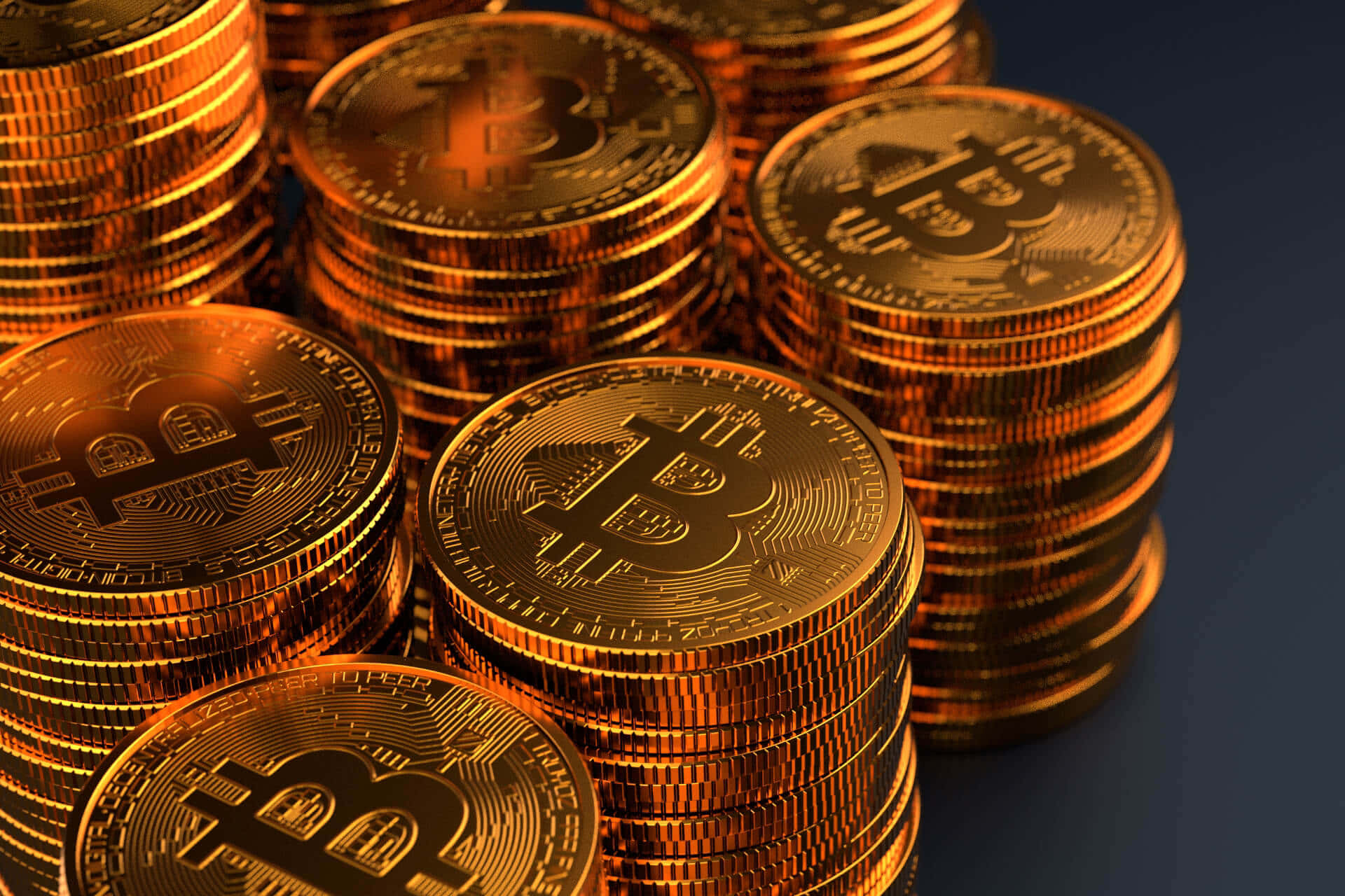 數位資產比特幣的視覺呈現 壁紙 — 一堆閃閃發光的金色比特幣硬幣，帶有浮雕的「B」符號，以特寫構圖排列。