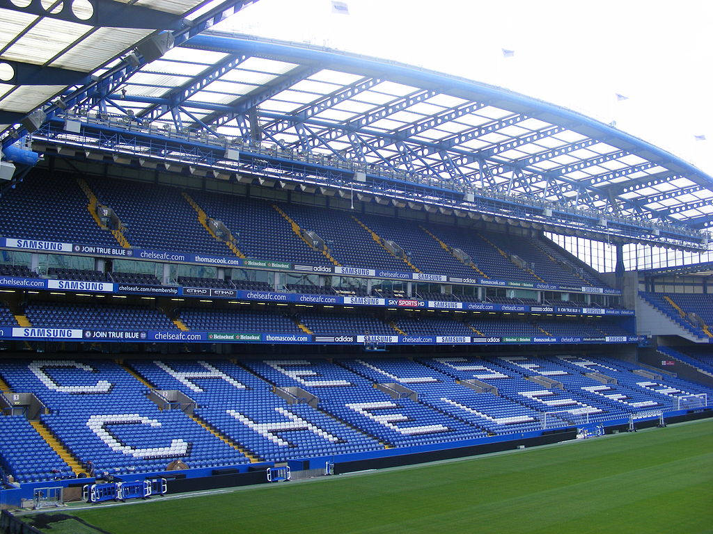 空的藍色體育場座位在綠色球場上以白色字母拼出CHELSEA。