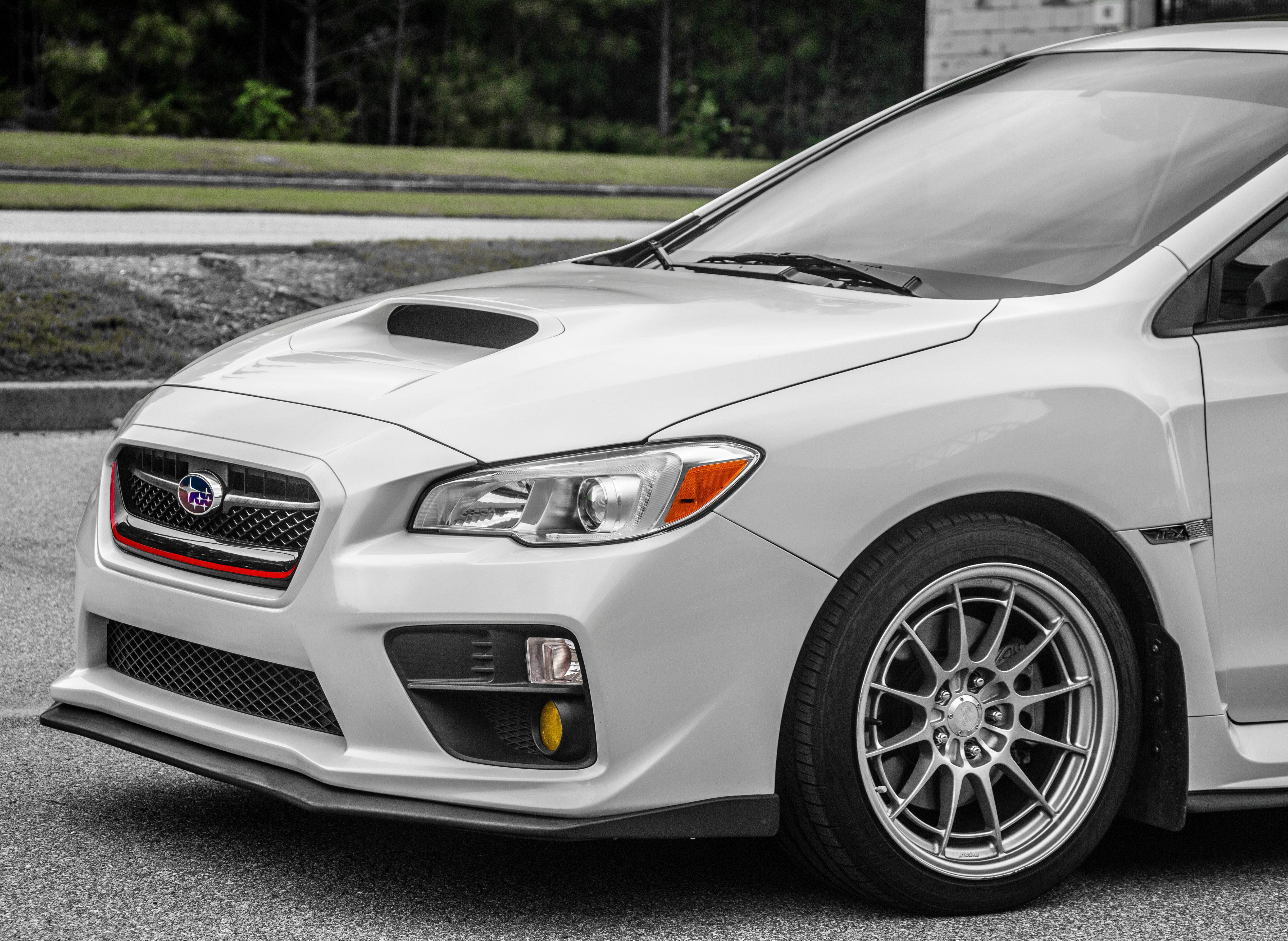 斯巴魯Impreza側面視圖照片 壁紙 — 一輛時尚的白色 Subaru WRX STI 跑車，帶有紅色格柵裝飾和定制合金輪圈，停在瀝青路面上。