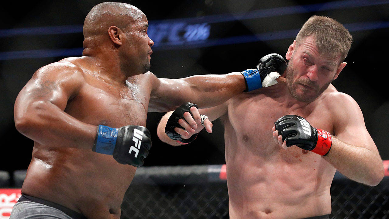 斯蒂普·米奧奇遭左勾拳擊中 壁紙 — 兩名肌肉發達的拳手在激烈的UFC比賽中碰撞，汗水飛濺，其中一人打出強力一拳。