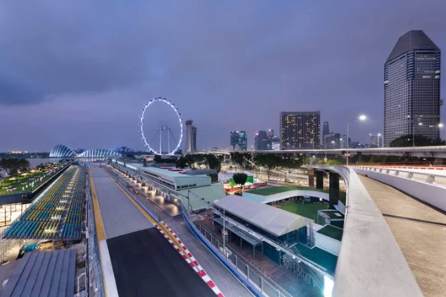 黃昏時的新加坡一級方程式賽車賽道，城市天際線和亮燈的摩天輪。
