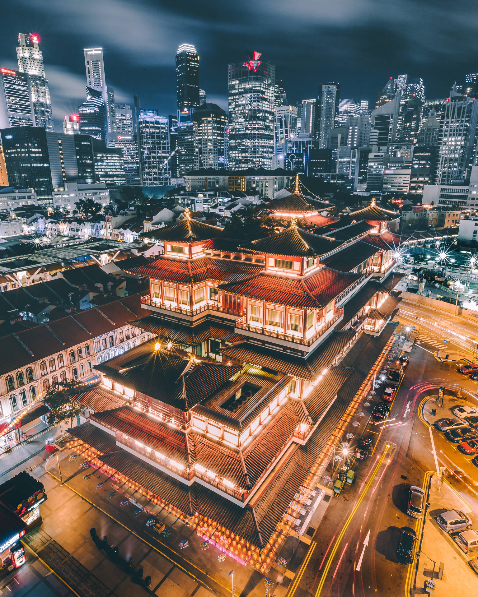 夜晚發光的傳統寺廟，被城市燈光和車流軌跡包圍。
