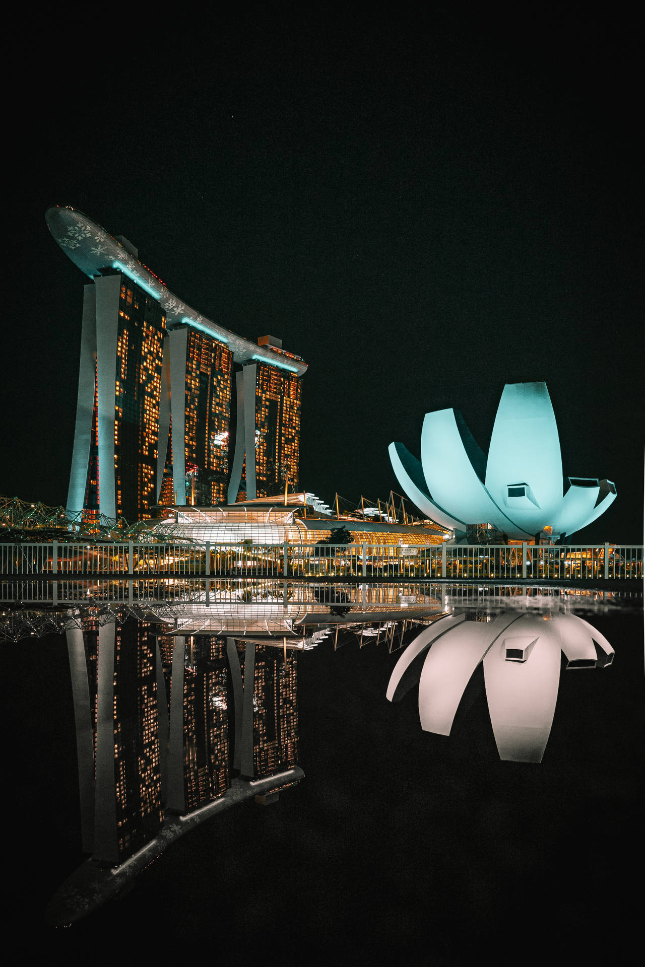夜晚發光的濱海灣金沙和藝術科學博物館，完美水面倒影。
