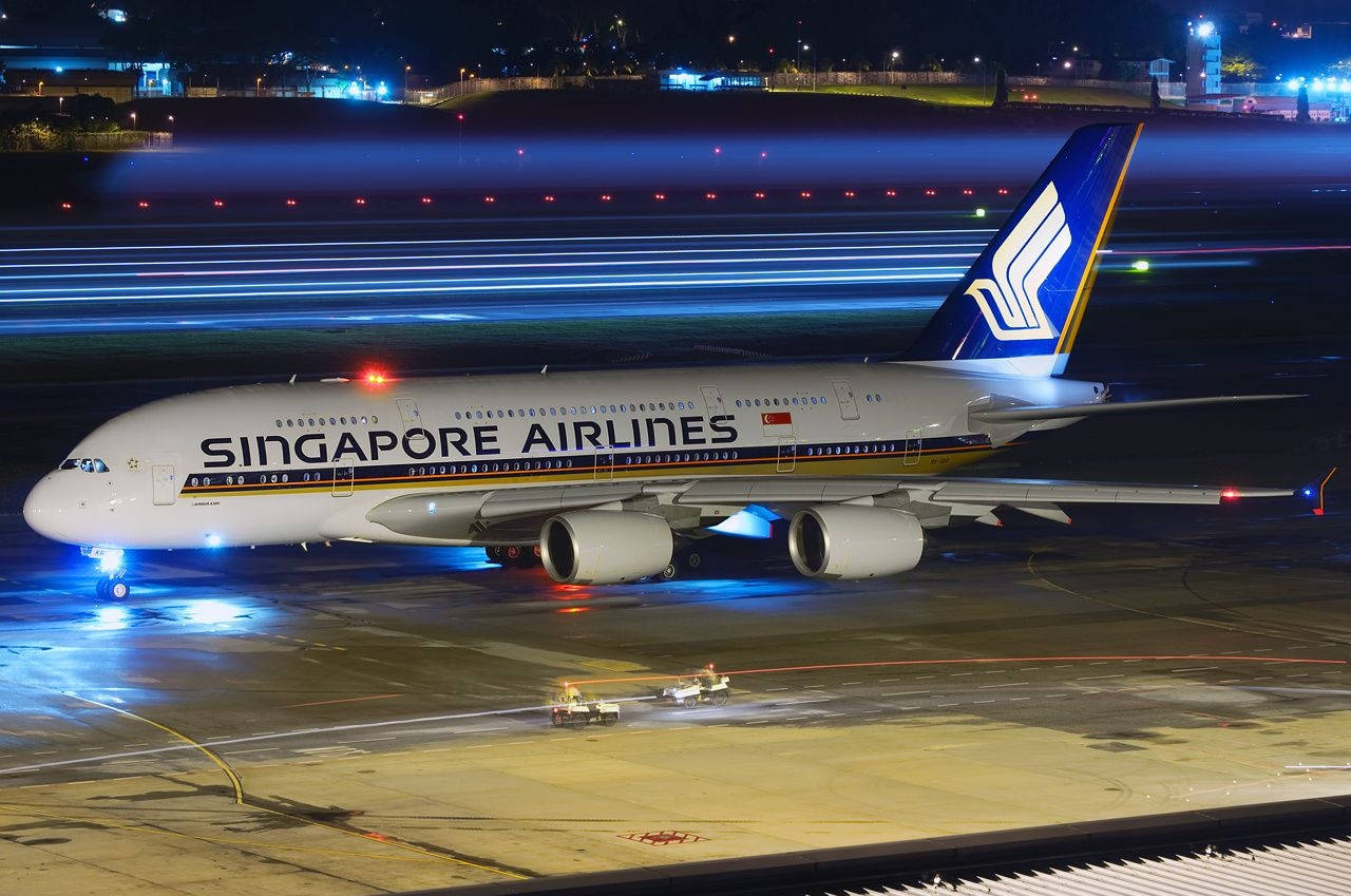 新加坡航空A380在夜間跑道上有藍色燈光掠過。