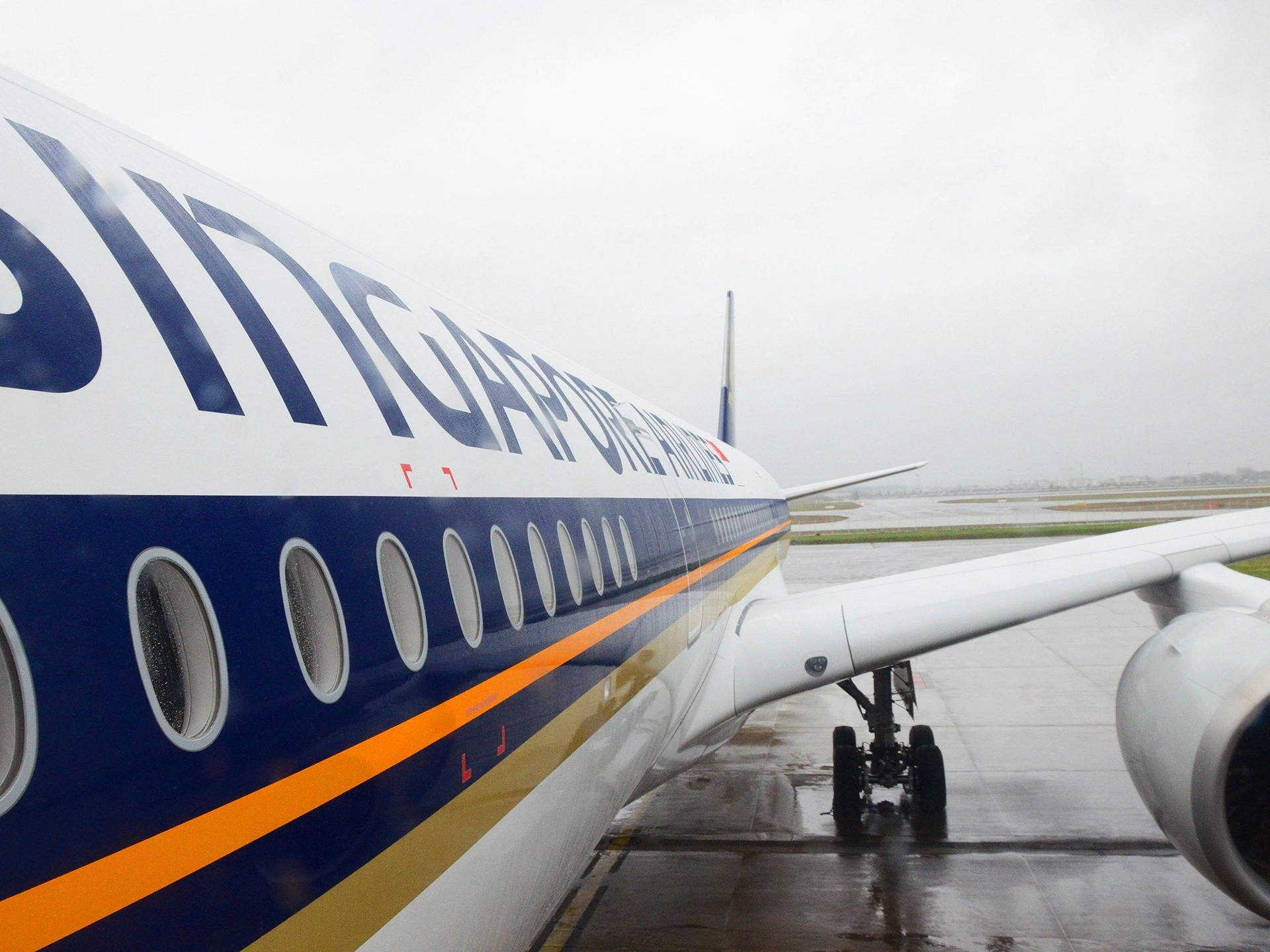 新加坡航空飛機在潮濕的跑道上，天氣有雨。