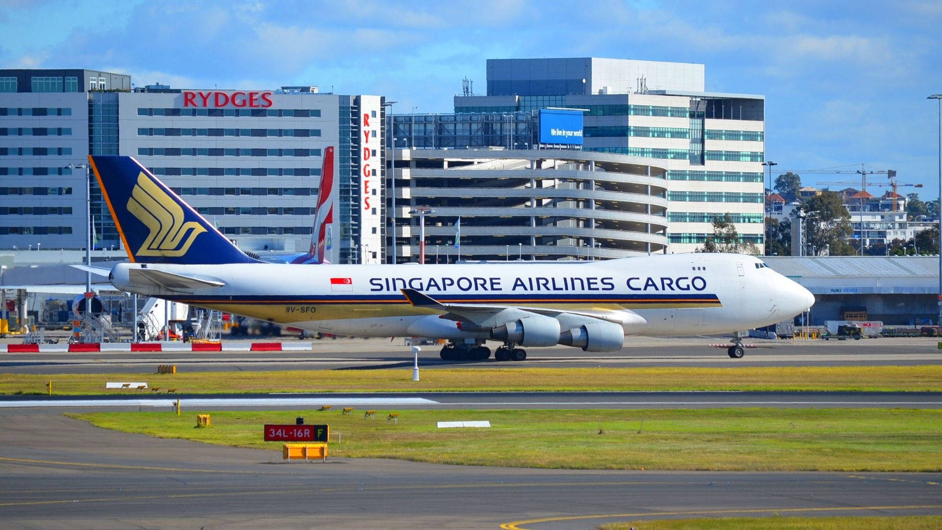 新加坡航空貨運飛機在機場跑道上，背景有建築物。
