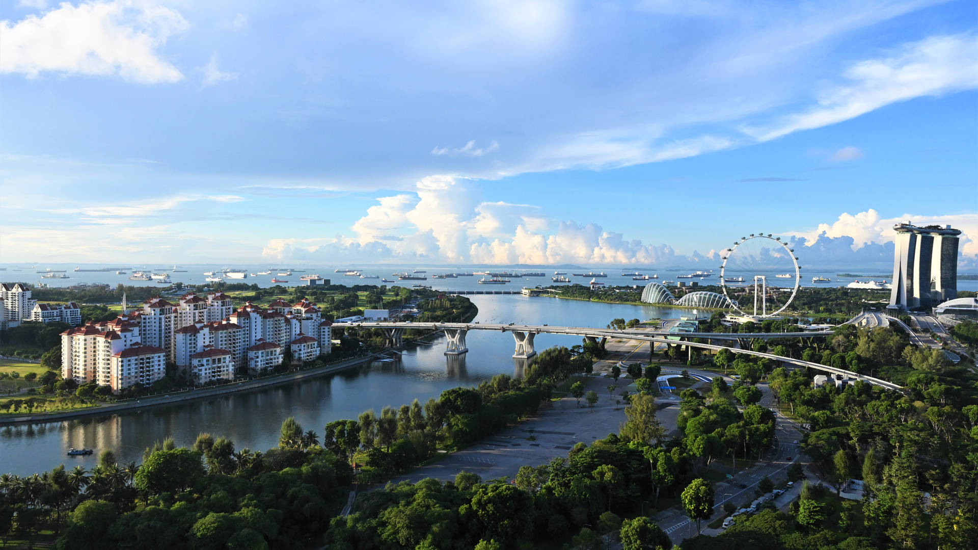 新加坡城市景觀，包括濱海灣金沙和新加坡摩天觀景輪，在明亮藍天下。