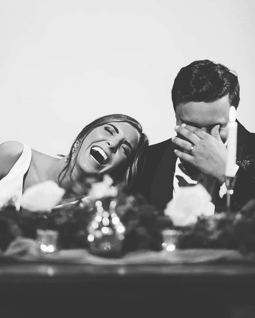 Black And White Wedding 桌布 壁紙 — 新娘開懷大笑，新郎在婚宴桌上忍俊不禁地掩面。