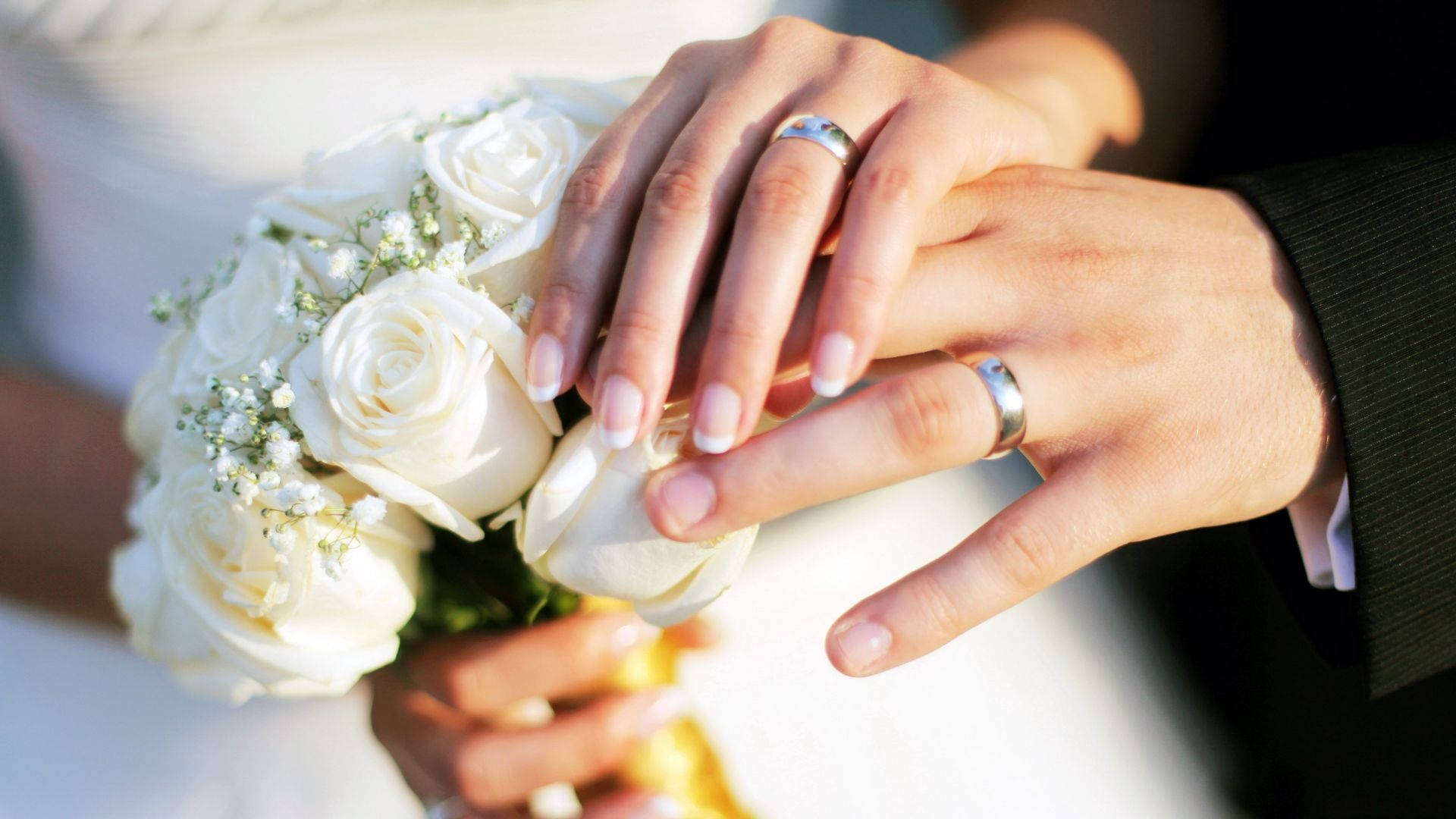 新婚夫婦婚戒 壁紙 — 溫柔特寫交織的婚禮手捧白玫瑰，戒指在柔和日光中閃爍。