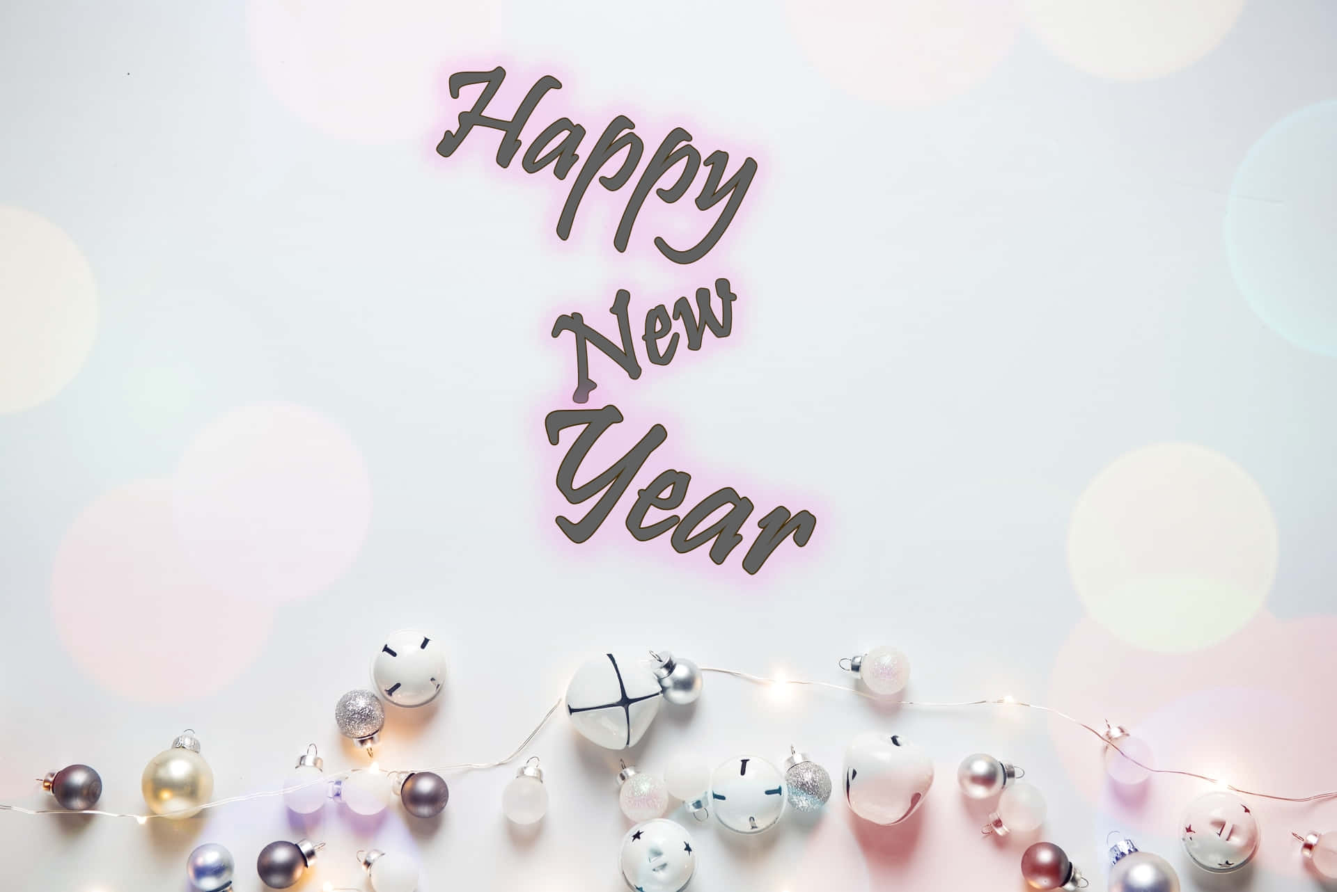 「新年快樂！」 壁紙 — 新年快樂文字在柔和散景背景上，在一串節日裝飾品和閃爍燈光上方微微發光。