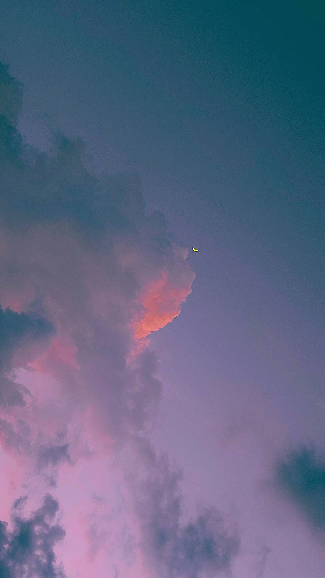暮色中彩色雲層後的新月