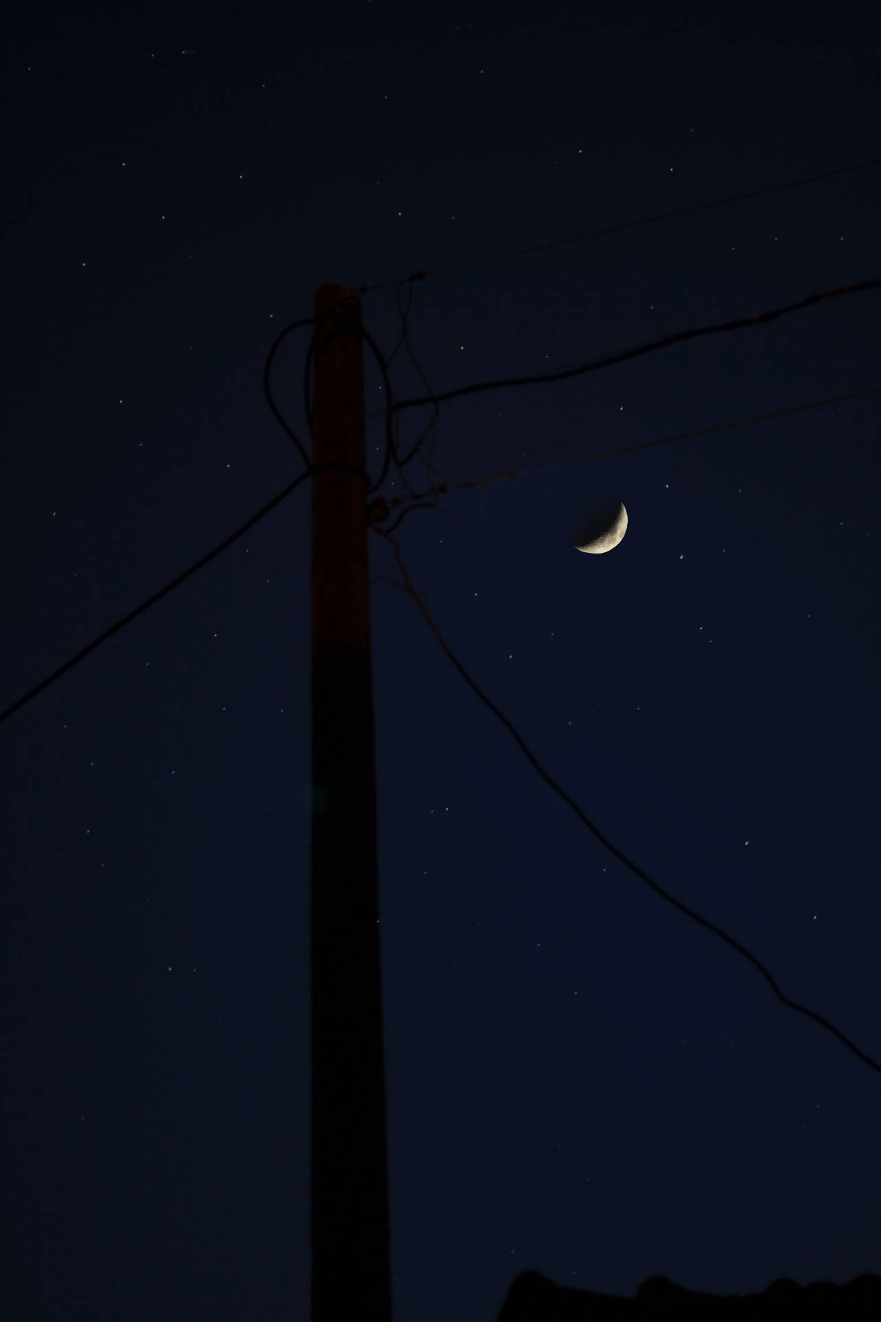 夜晚電線桿後的月牙和星星