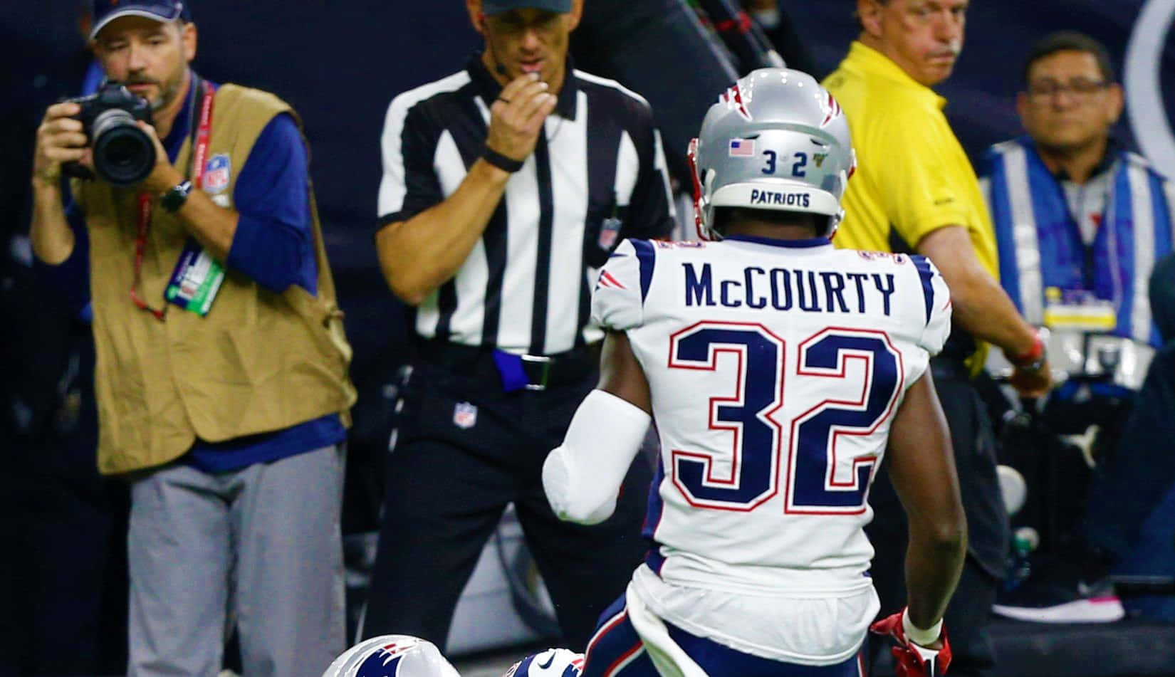 Devin Mccourty 桌布 壁紙 — 新英格蘭愛國者隊球員麥考蒂32號離場，裁判示意，攝影師捕捉這一刻。