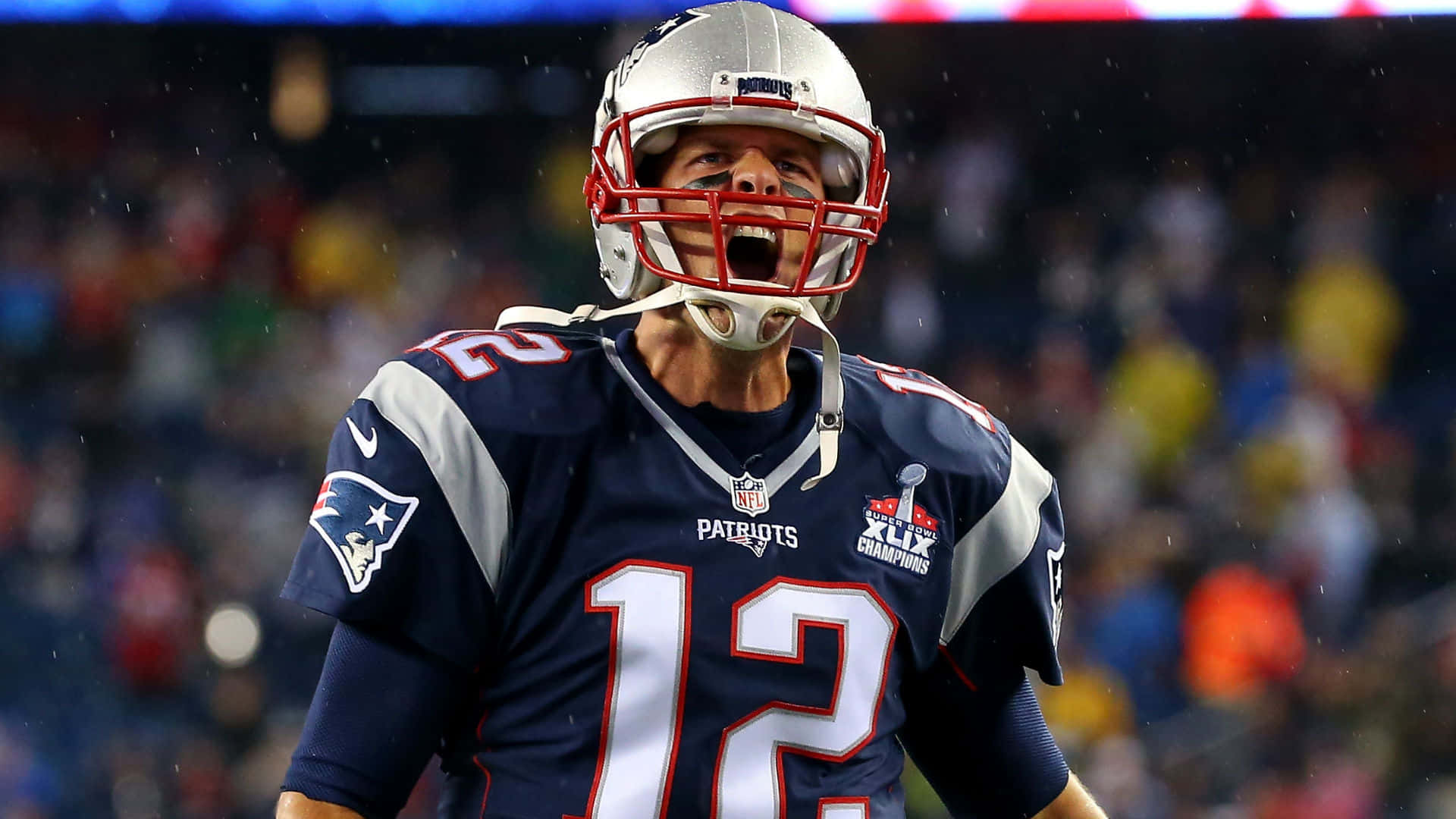美式足球四分衛在夜間比賽中雨中慶祝勝利。