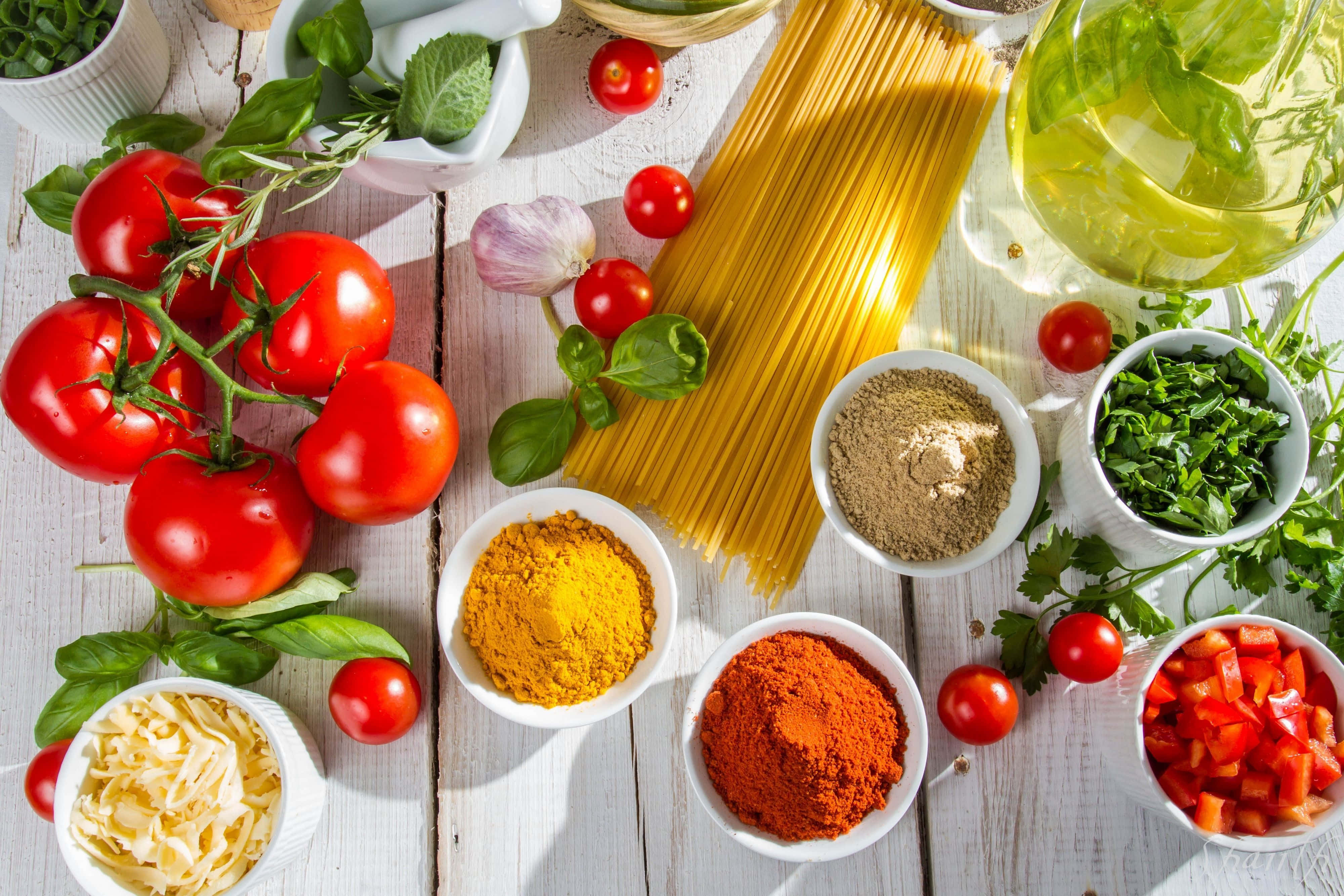 Spices 桌布 壁紙 — 新鮮充滿活力的意粉食材，包括番茄、羅勒、大蒜、香料和麵條，排列在質樸的白色木質表面上。