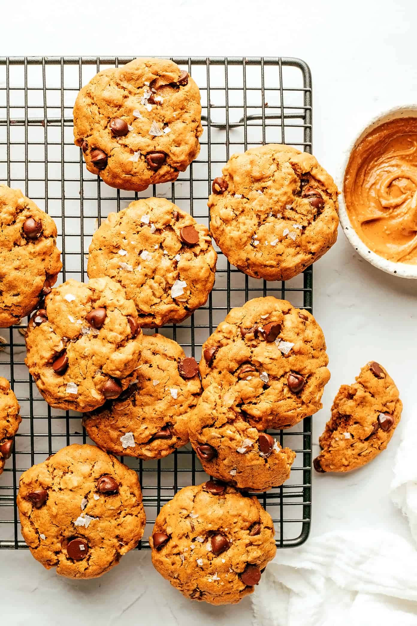 曲奇 桌布 壁紙 — 新鮮出爐的朱古力曲奇撒上海鹽，放在金屬架上，旁邊放一碗焦糖醬。