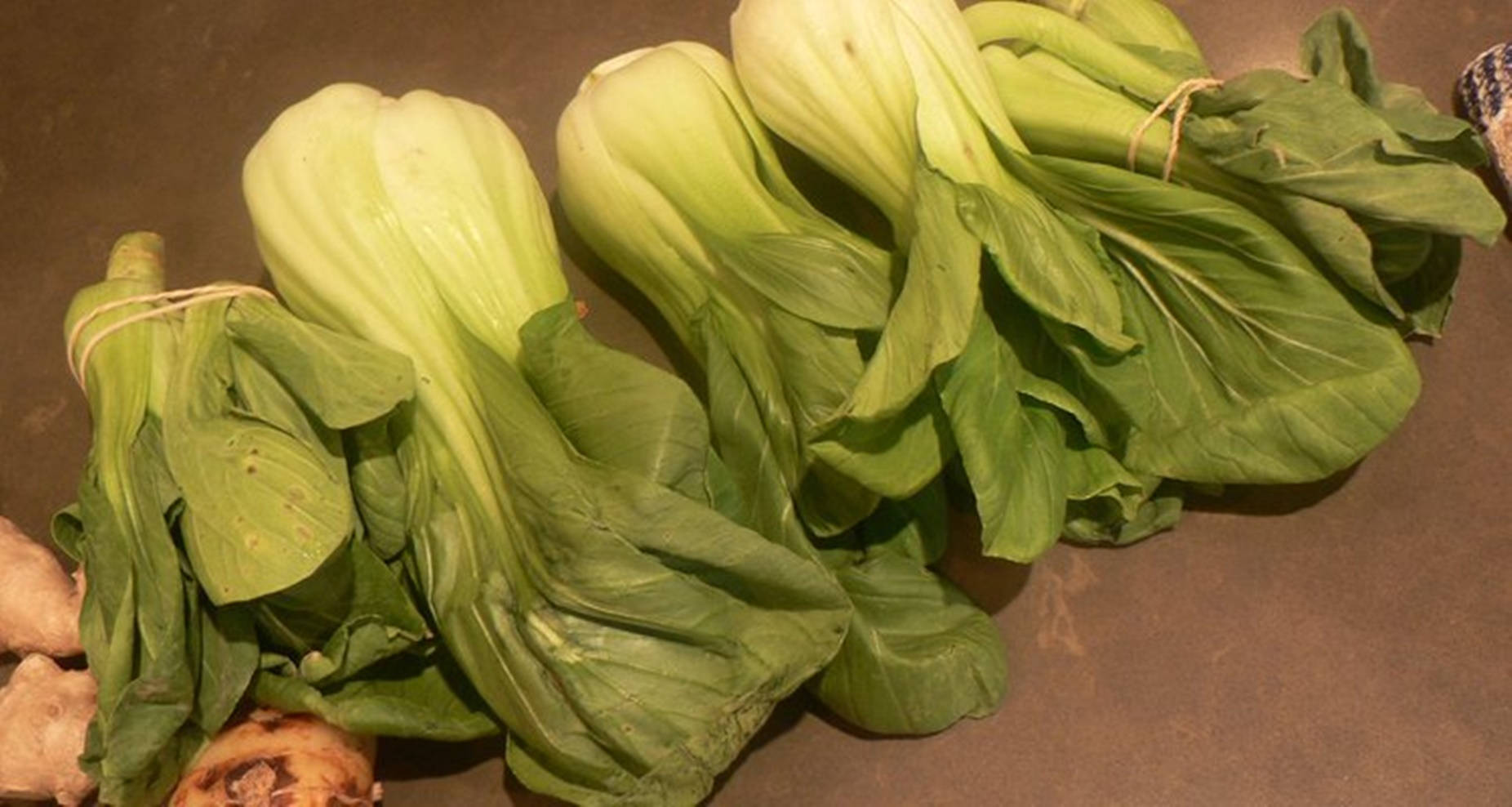 廚房枱面上的新鮮小白菜和薑根。
