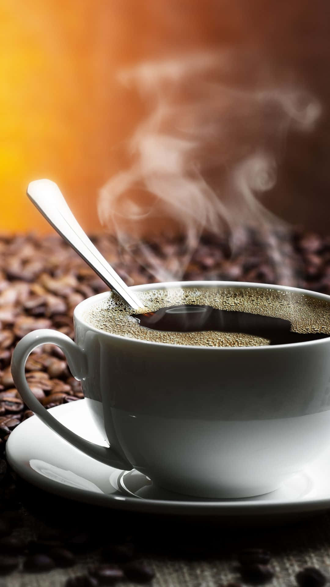 冒著蒸氣的咖啡杯連湯匙放在碟子上，周圍有咖啡豆。