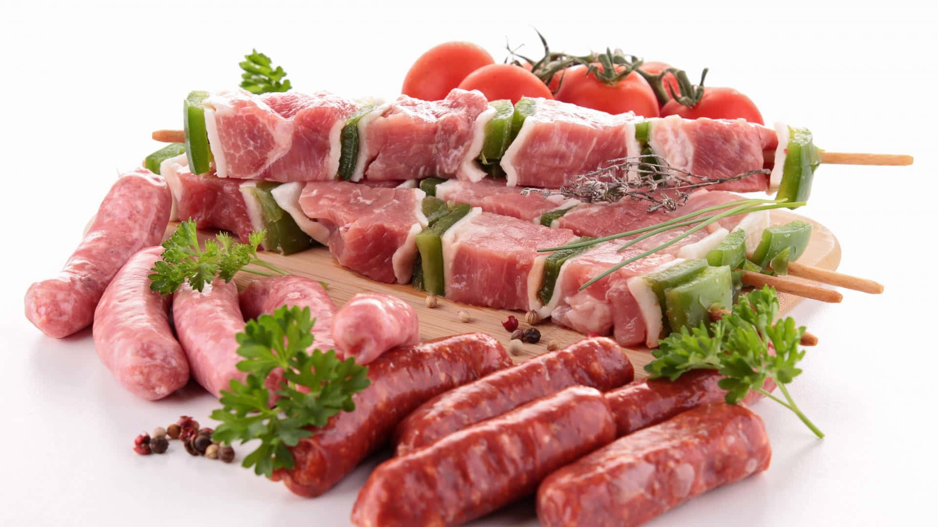 meat 桌布 壁紙 — 新鮮生肉串和香腸，飾以歐芹和車厘茄，放在木板上。