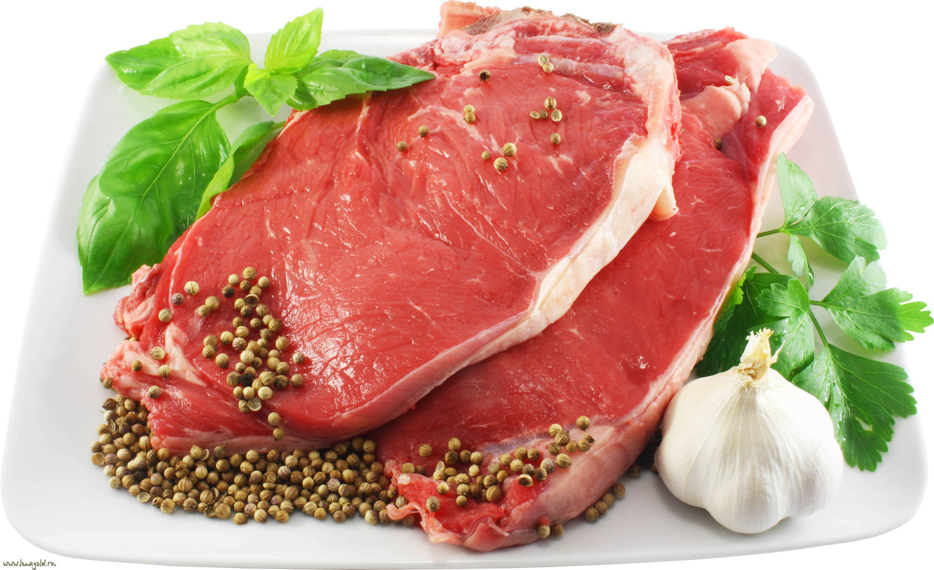 白色碟上的生牛肉扒配香草和香料。