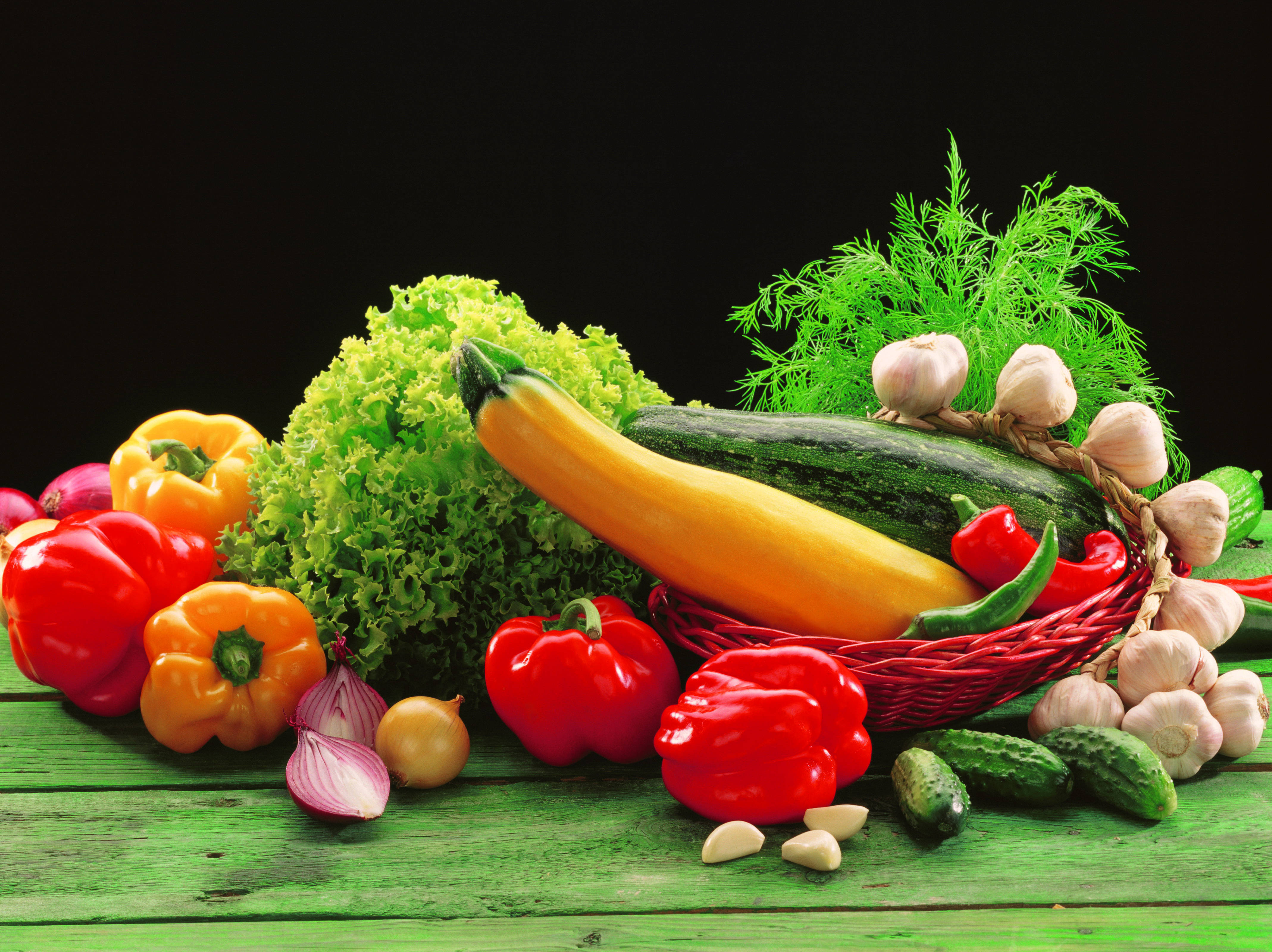 Vegetable 桌布 壁紙 — 新鮮蔬菜如燈籠椒、翠玉瓜和大蒜的鮮豔排列，置於經風化的綠色木質表面上，背景為黑色。