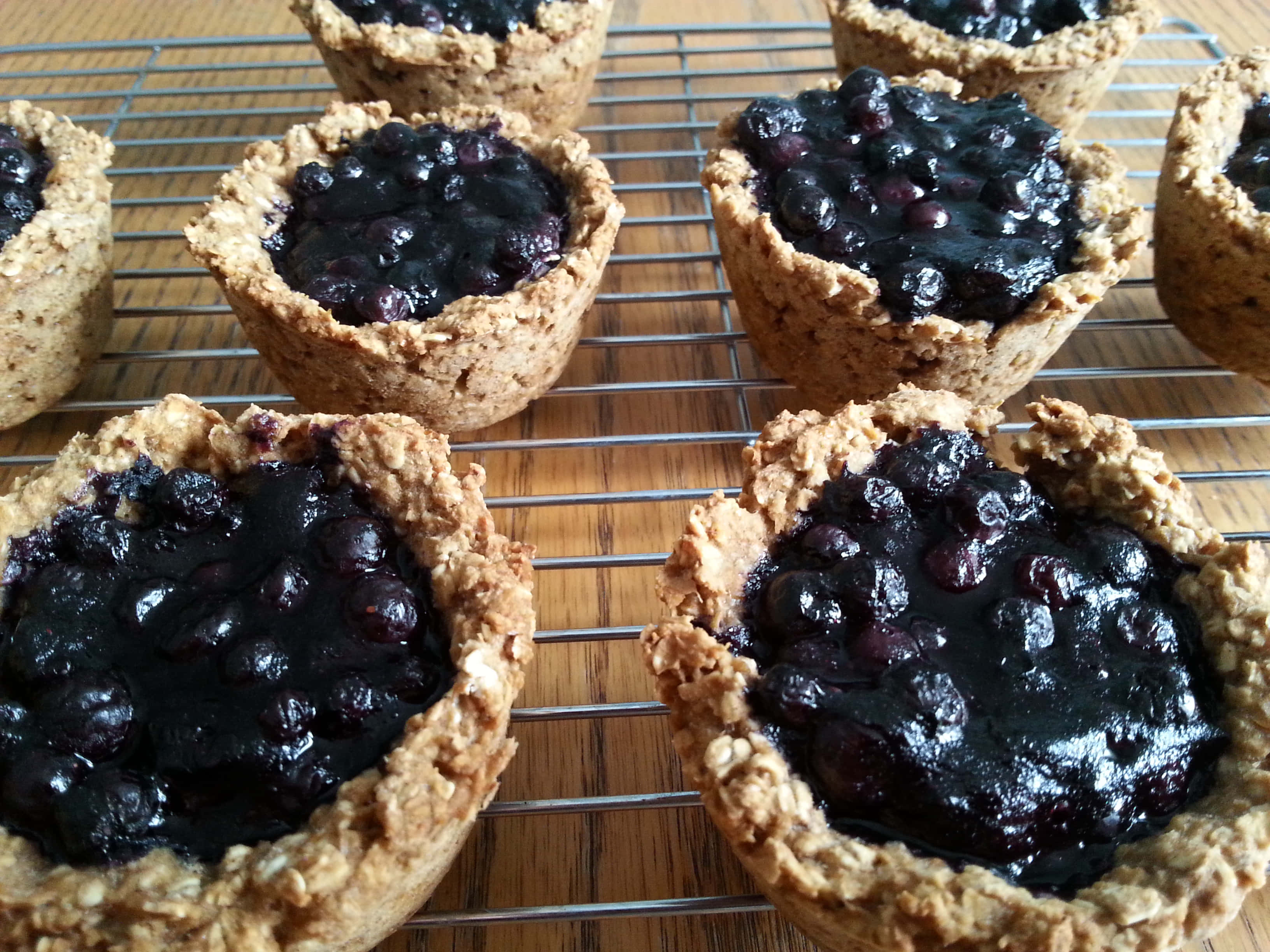 Blueberries Tart 桌布 壁紙 — 新鮮藍莓燕麥撻在竹面上嘅金屬架上冷卻中。