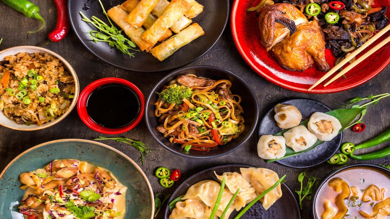各種亞洲菜餚，包括餃子、麵條和春卷，配以新鮮裝飾和辣椒。