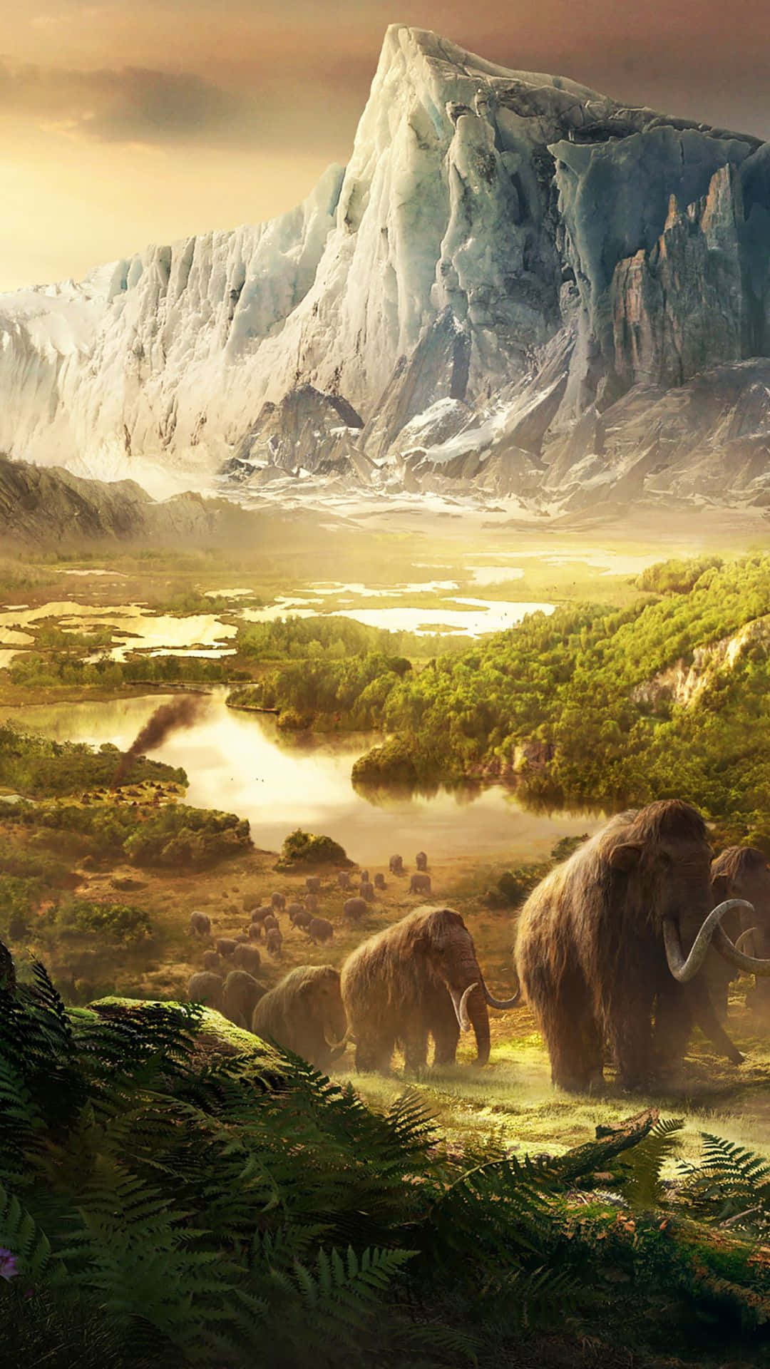 於 iPhone XS 生存《孤島驚魂3》狂野世界 壁紙 — 一群猛獁象在茂盛的山谷中吃草，山谷上方是高聳的冰川，沐浴在金色的日落光芒中。
