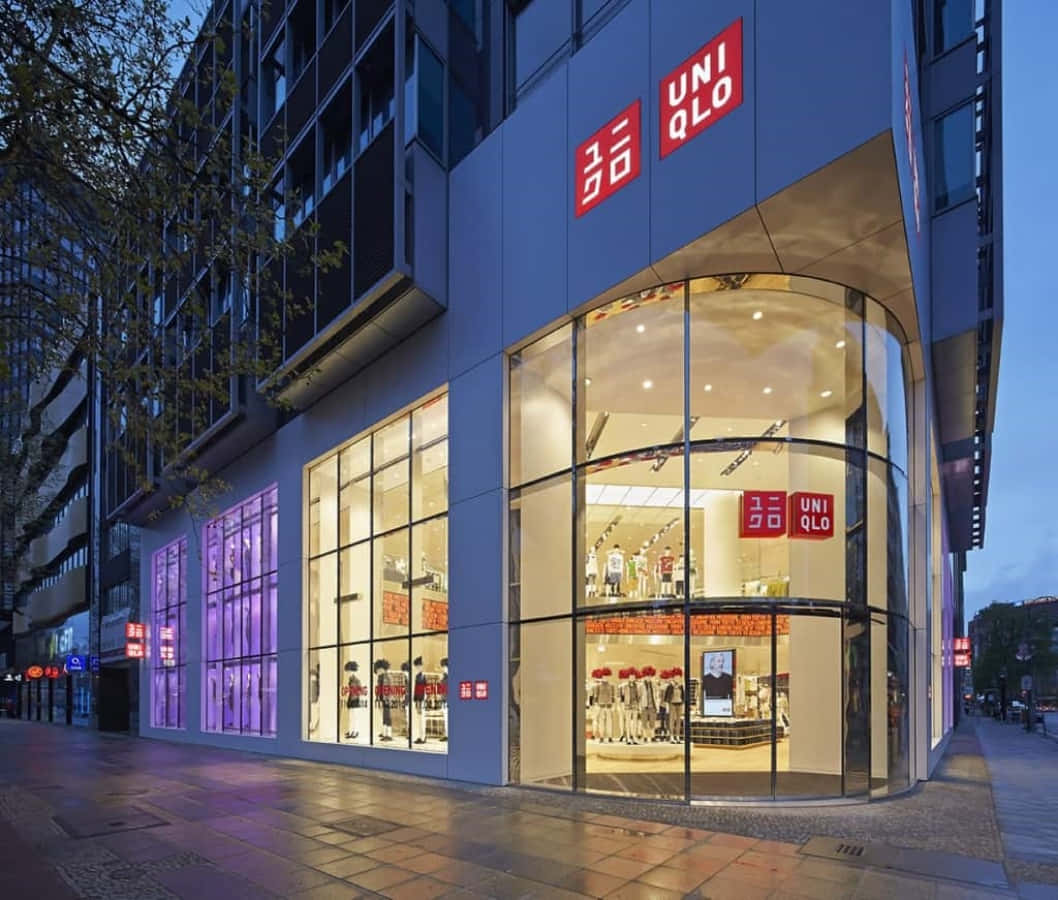 黃昏時的Uniqlo商店，藍色建築上有明亮的窗戶和紅色標誌。