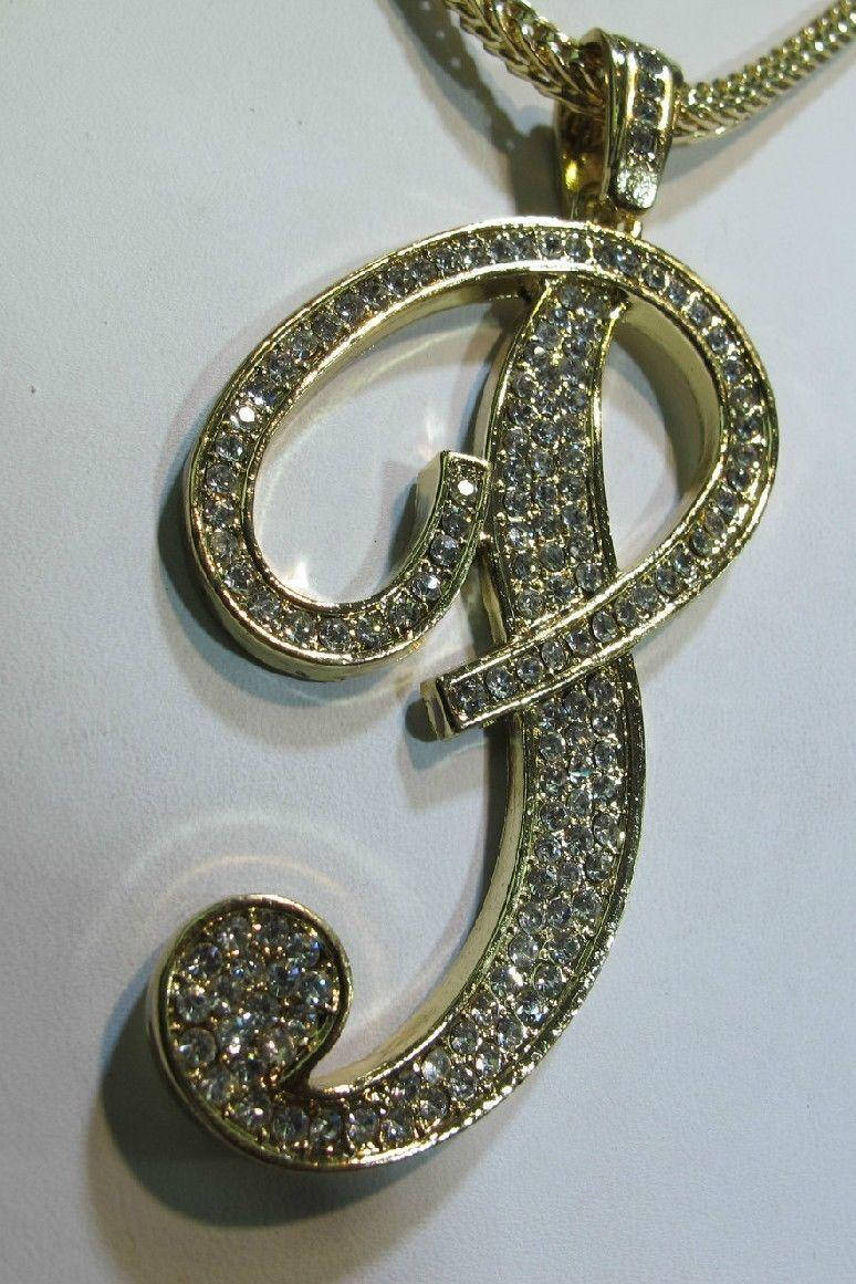 金色字母J吊墜，覆蓋鑽石，白色背景。