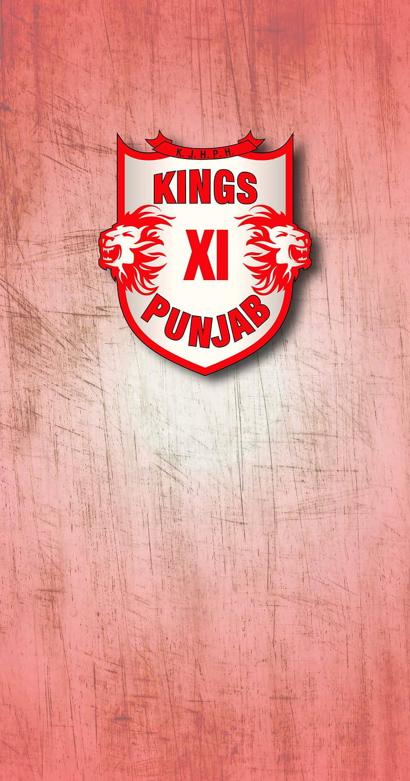 旁遮普王隊盾形徽章 壁紙 — Kings XI Punjab 板球隊標誌居中於有紋理的粉紅色刮痕背景上。