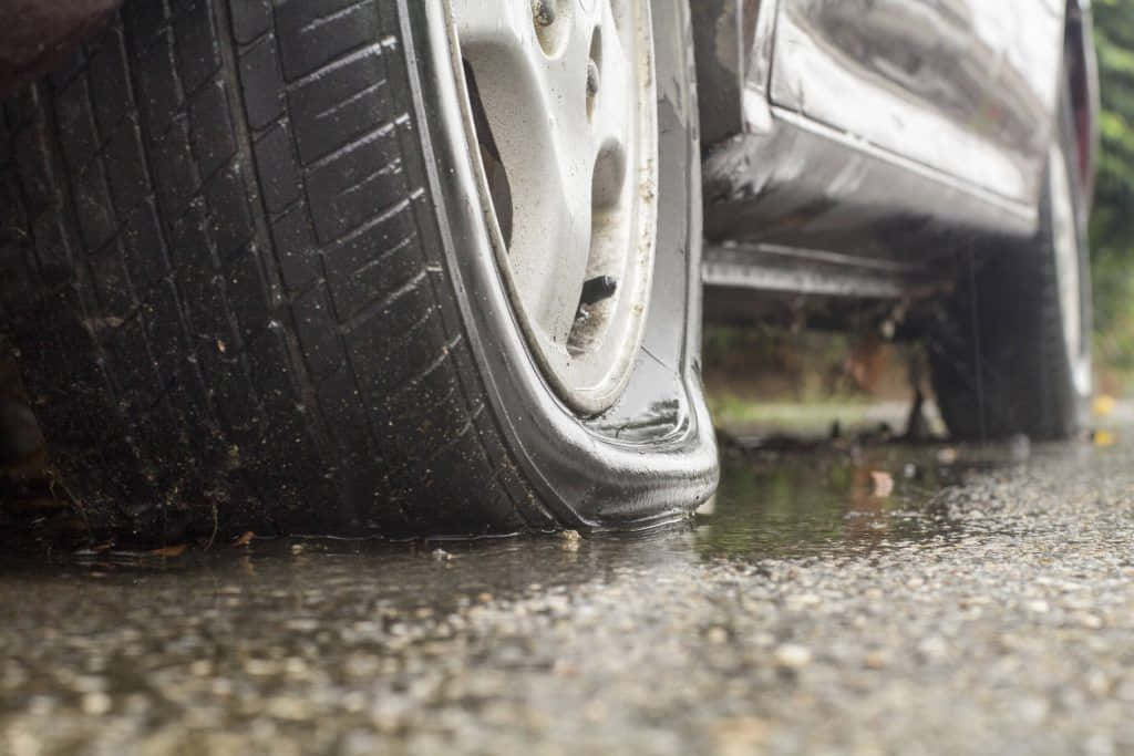 雨後濕滑泥濘路面上嘅扁車胎