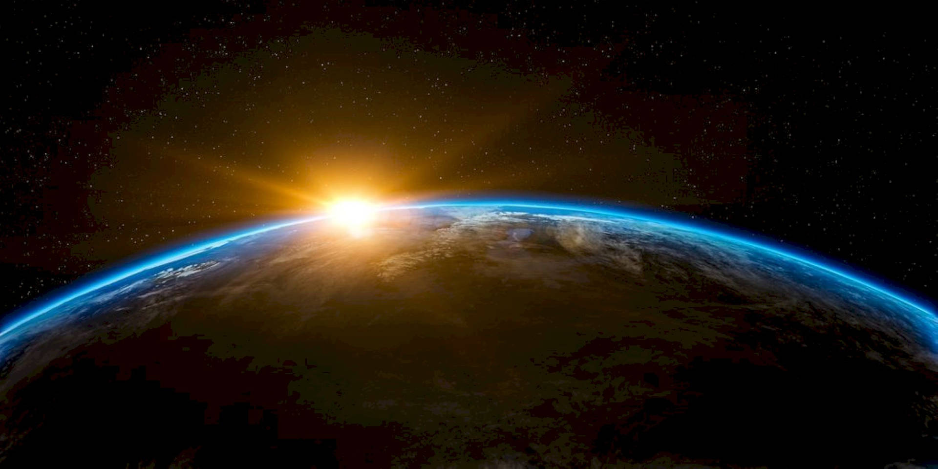太陽在太空中從地球彎曲的地平線上升起，星星可見。