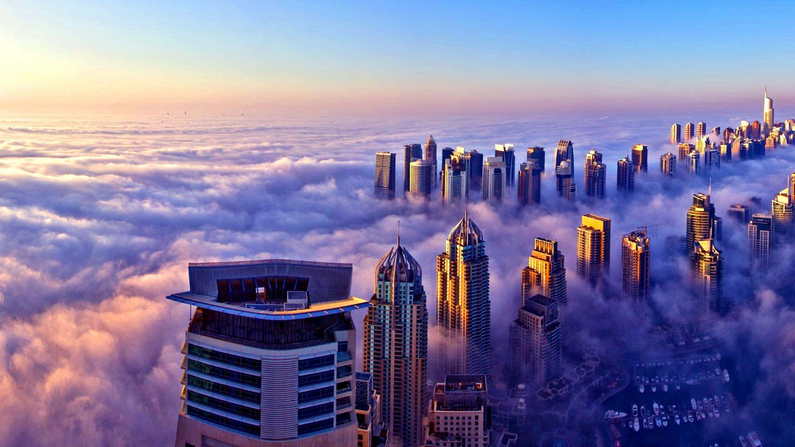 Uae 桌布 壁紙 — 日出時分，金色陽光沐浴城市景觀，摩天大樓穿透雲海的鳥瞰圖。