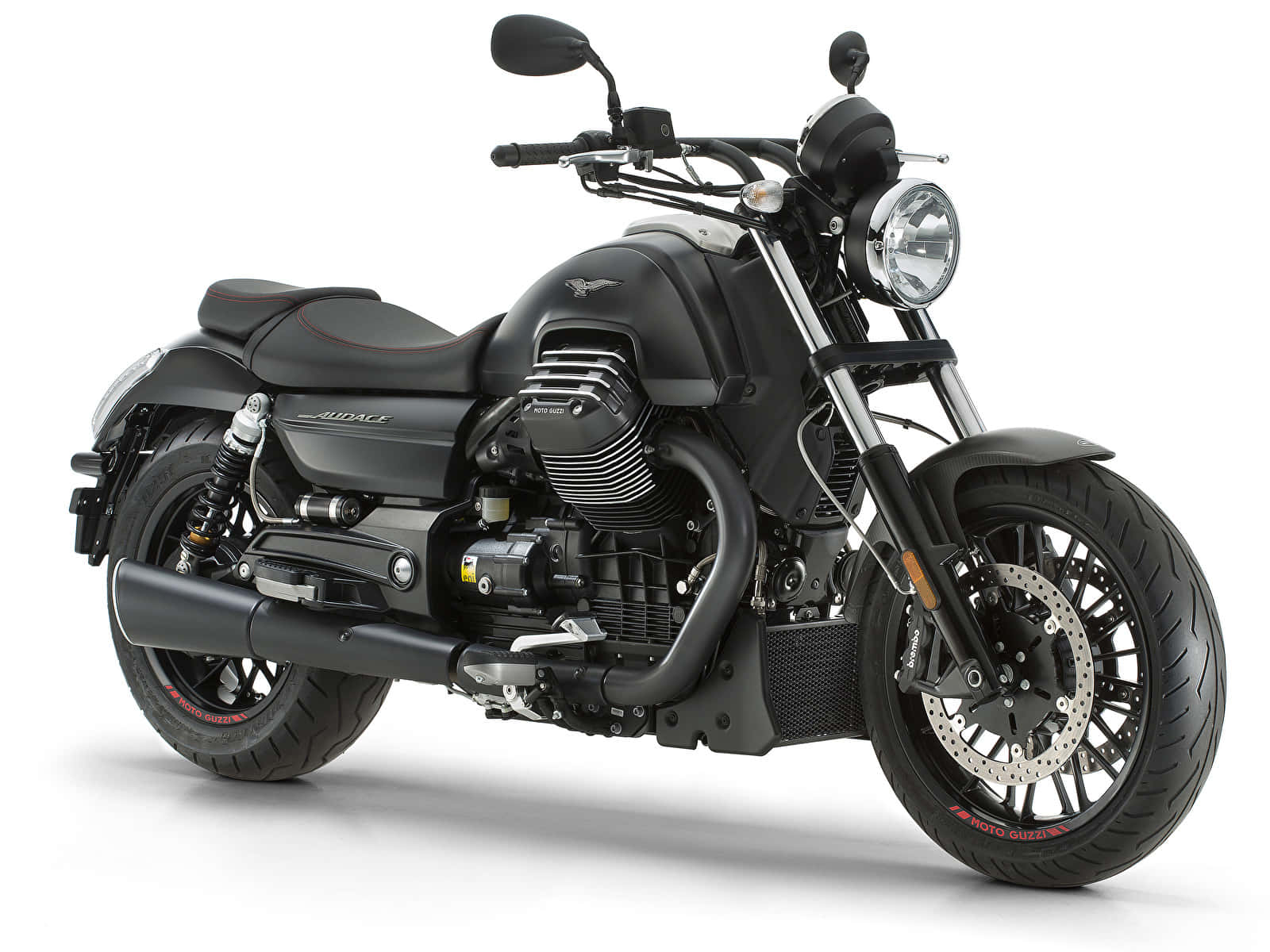 日出時分的 Moto Guzzi 機車 壁紙 — 一架時尚的啞光黑色電單車，帶有鍍鉻裝飾和紅色輪胎細節，在純白背景前蓄勢待發。