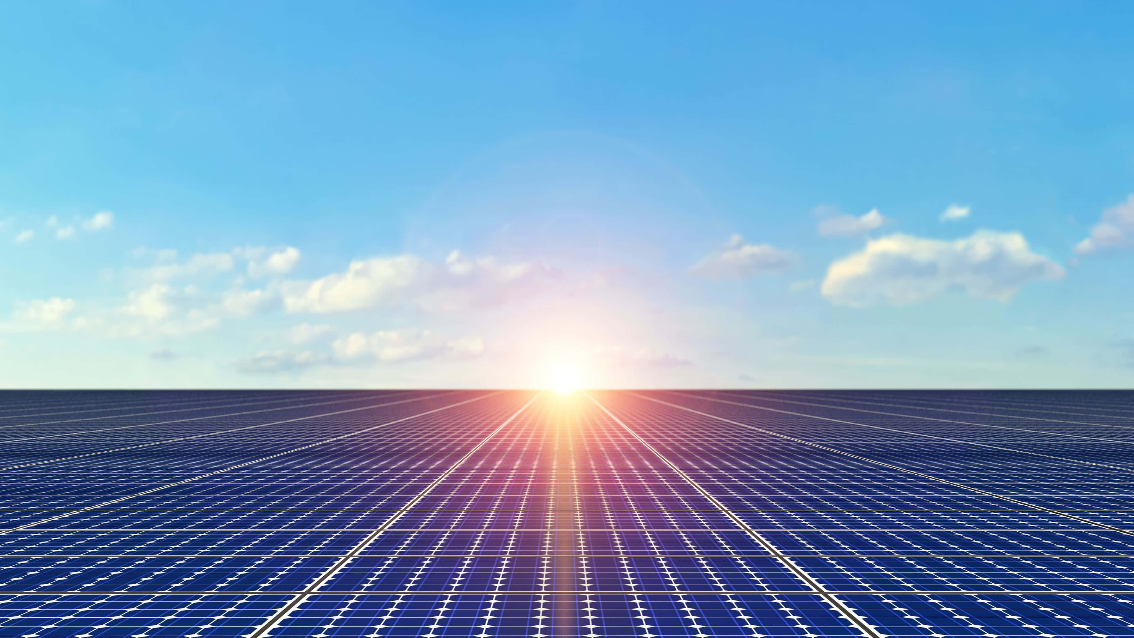 Solar Panel 桌布 壁紙 — 日出照耀著無盡的藍色太陽能板，在晴朗的天空和零星雲朵下延伸至地平線。
