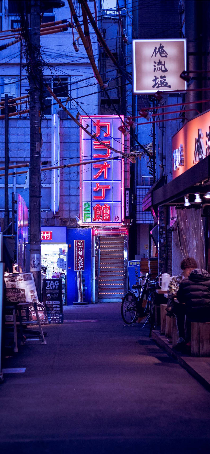 夜晚東京的霓虹小巷，有發光招牌和單車。