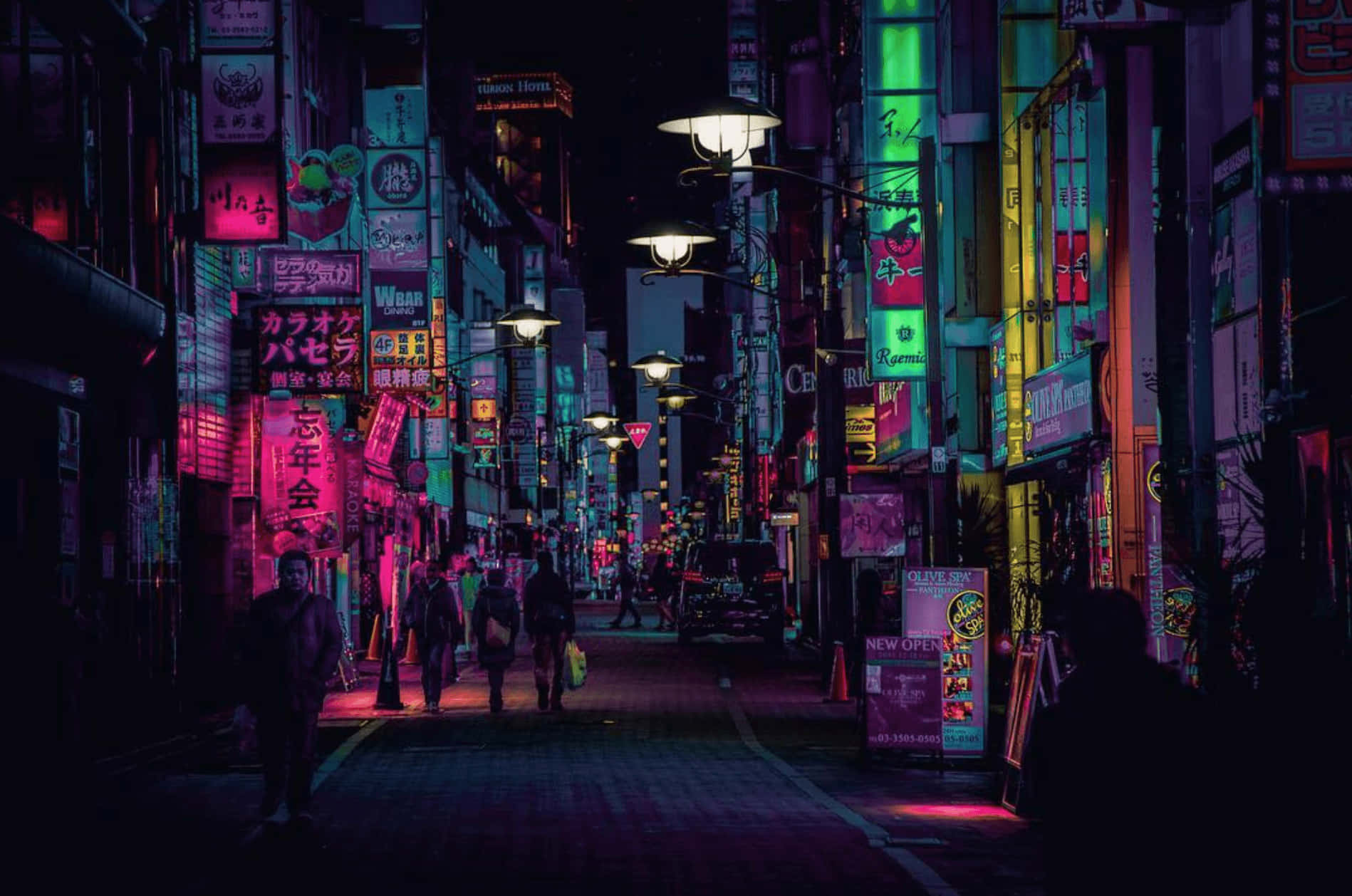 日式時尚店舖招牌夜景桌面壁紙 壁紙 — 夜晚東京一條狹窄小巷，沐浴在鮮豔的粉紅、綠色和藍色霓虹燈招牌中，在潮濕的路面上投射出色彩繽紛的倒影。
