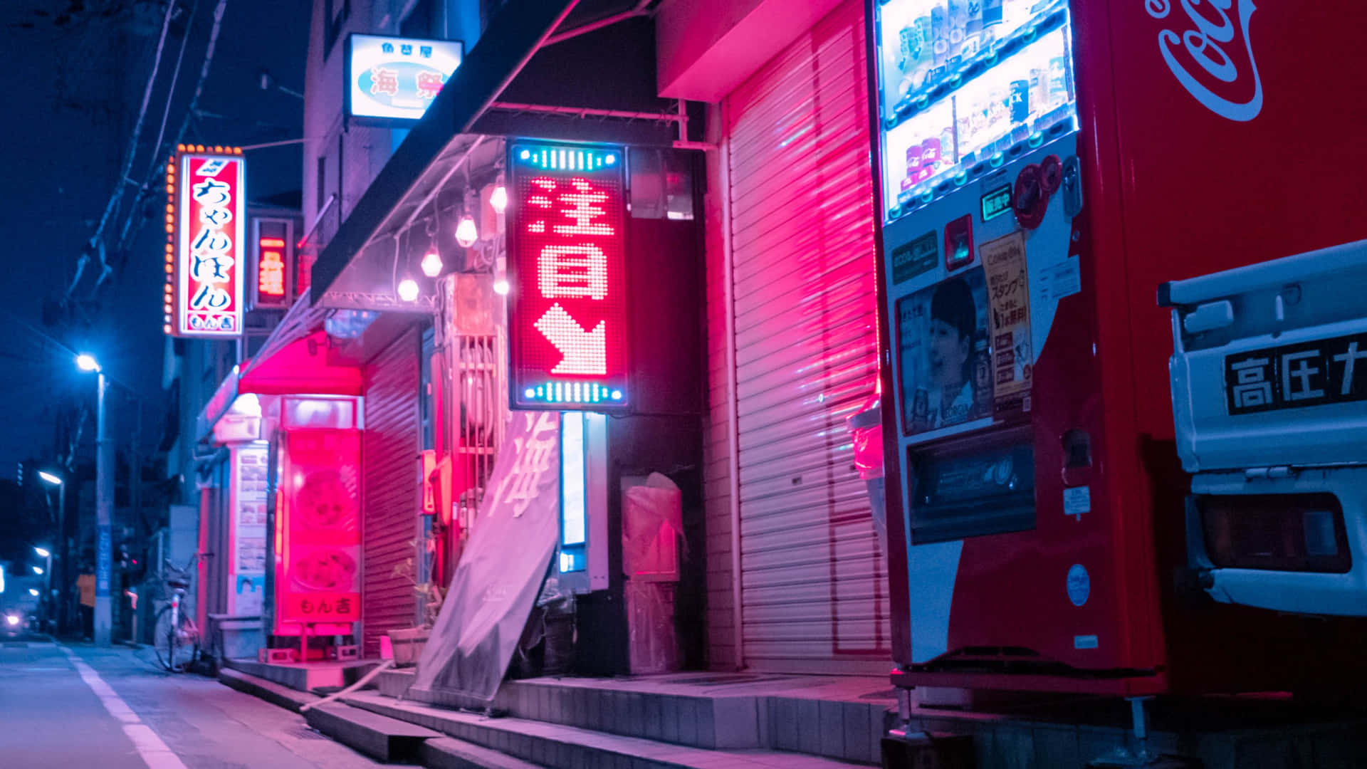 夜晚霓虹燈照亮的日本街道，有自動販賣機和關閉的商店。
