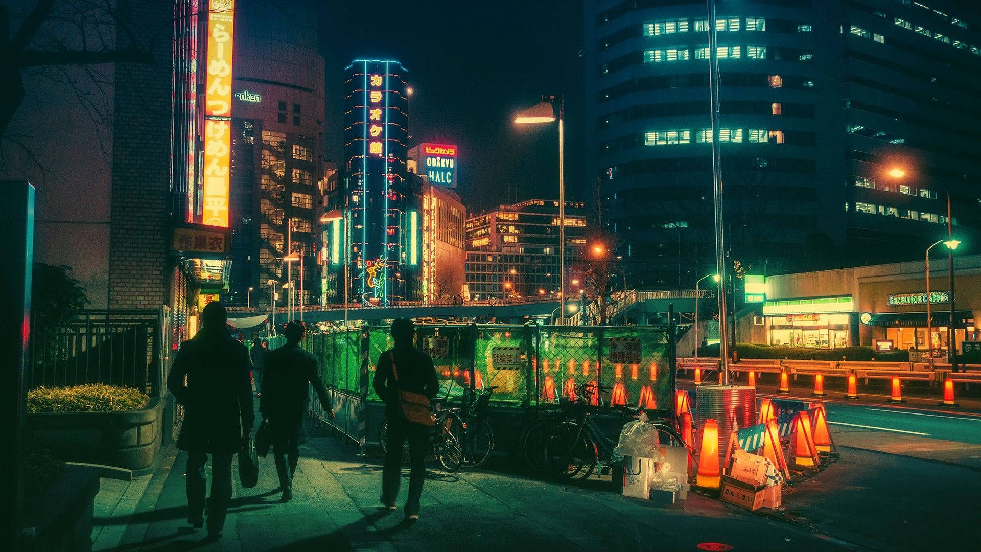 夜晚，三個人走在城市人行道上，頭頂是明亮的霓虹招牌。