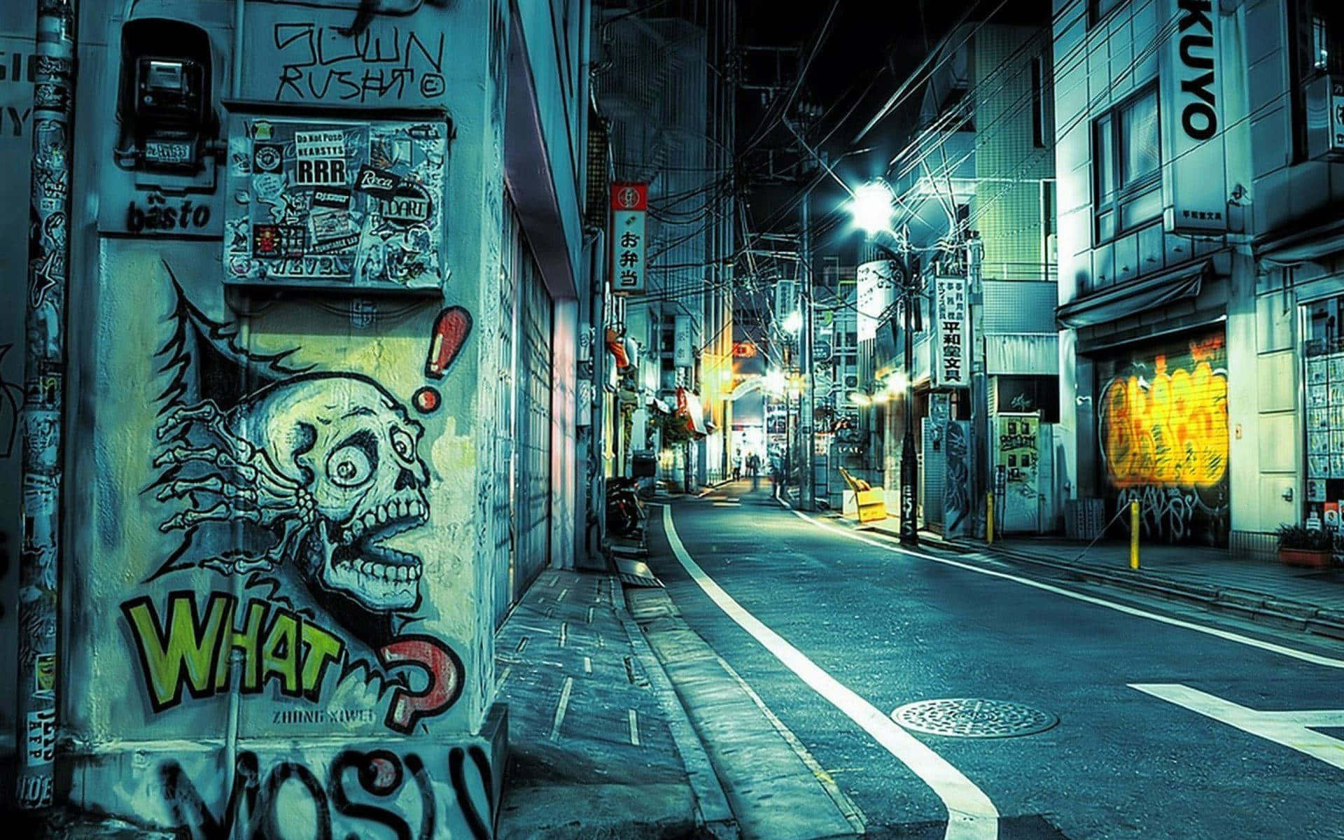 日式街區巷弄背景 壁紙 — 夜晚一條被霓虹燈照亮的城市小巷，牆上佈滿貼紙和塗鴉標籤，並有一幅大型骷髏塗鴉壁畫。