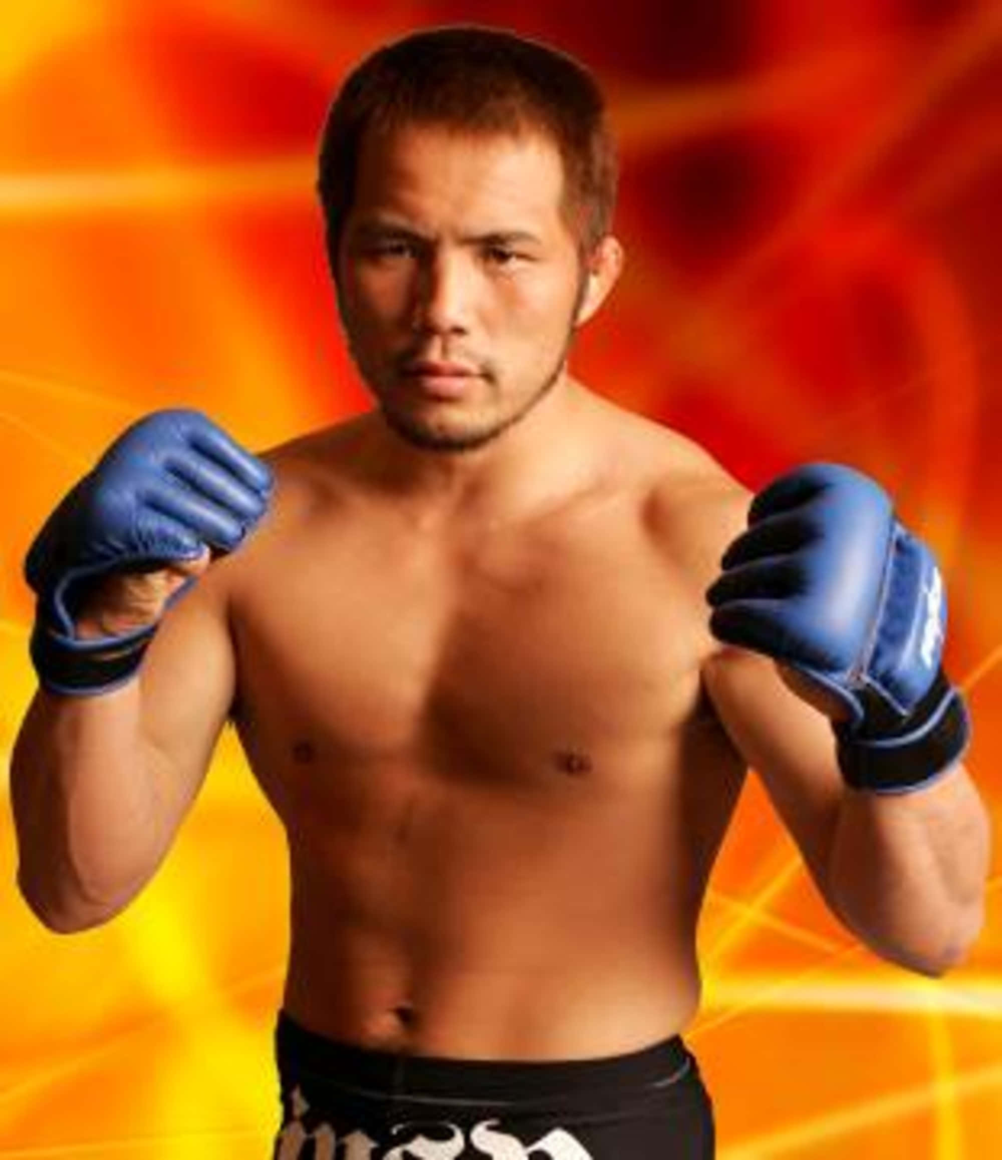 日本MMA選手櫻井隼人燃燒背景的酷炫肖像 壁紙 — 一位肌肉發達、戴著藍色手套的戰士，在熾熱的橙色和黃色背景前準備就緒。