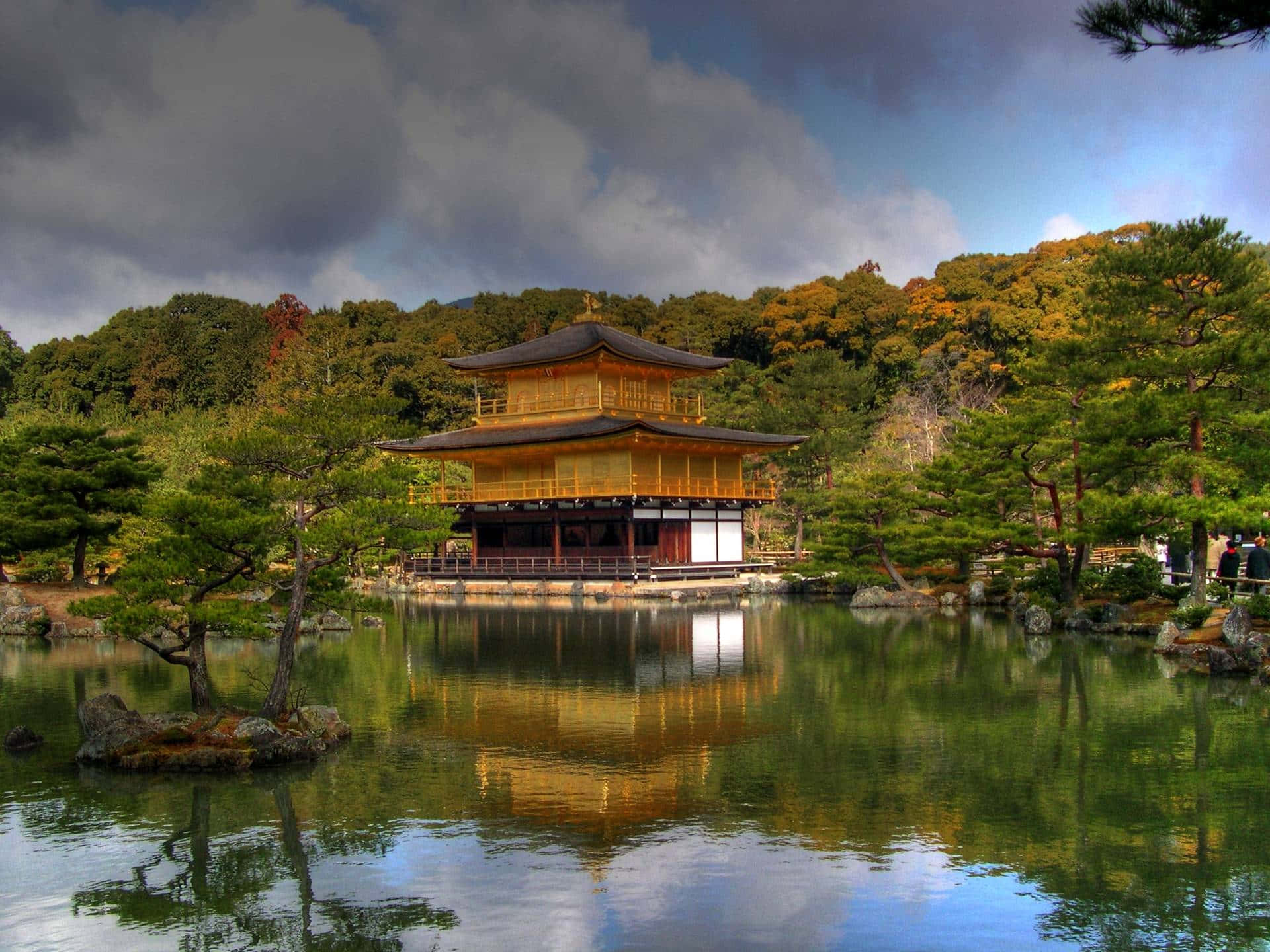 金色寺廟倒映在池塘中，周圍是秋天的樹木