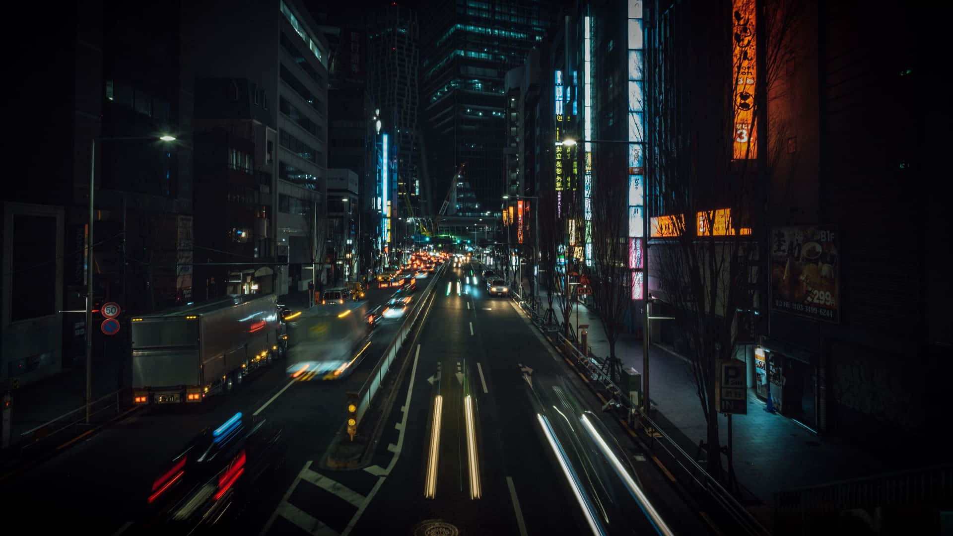 夜晚城市街道，有車燈光軌同發光嘅霓虹招牌。
