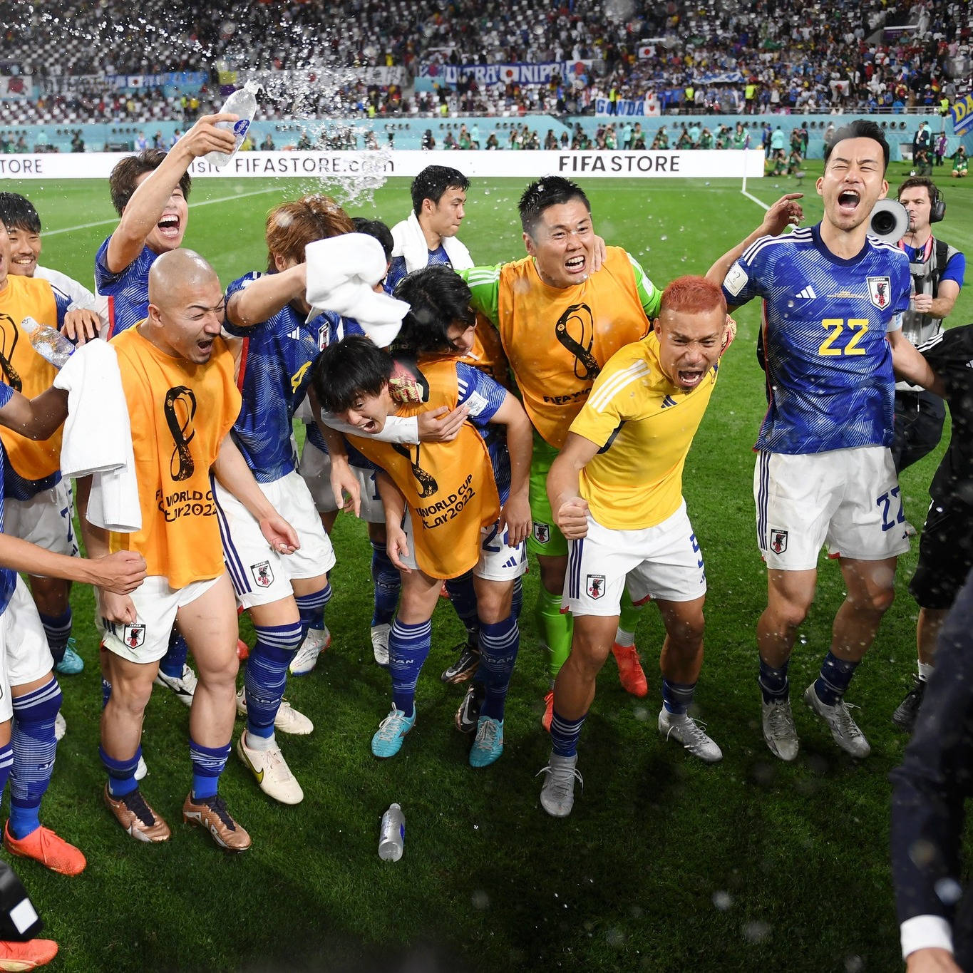 日本國家足球隊 高興吶喊 壁紙 — 日本足球運動員在體育場上瘋狂慶祝，噴灑香檳並擁抱勝利。